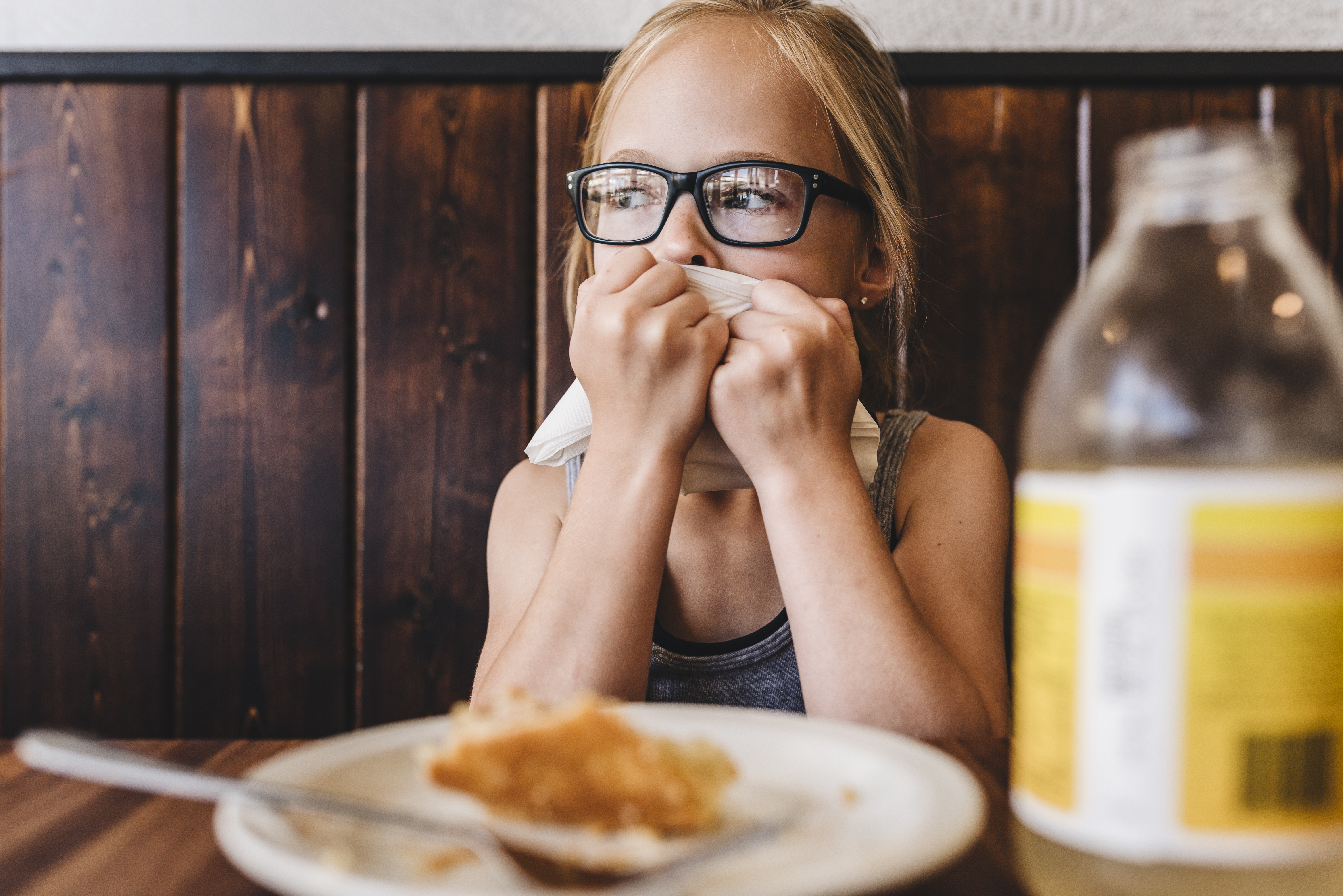 Kleines Mädchen isst und trinkt am Tisch in einem Cafe-Restaurant | Quelle: Getty Images