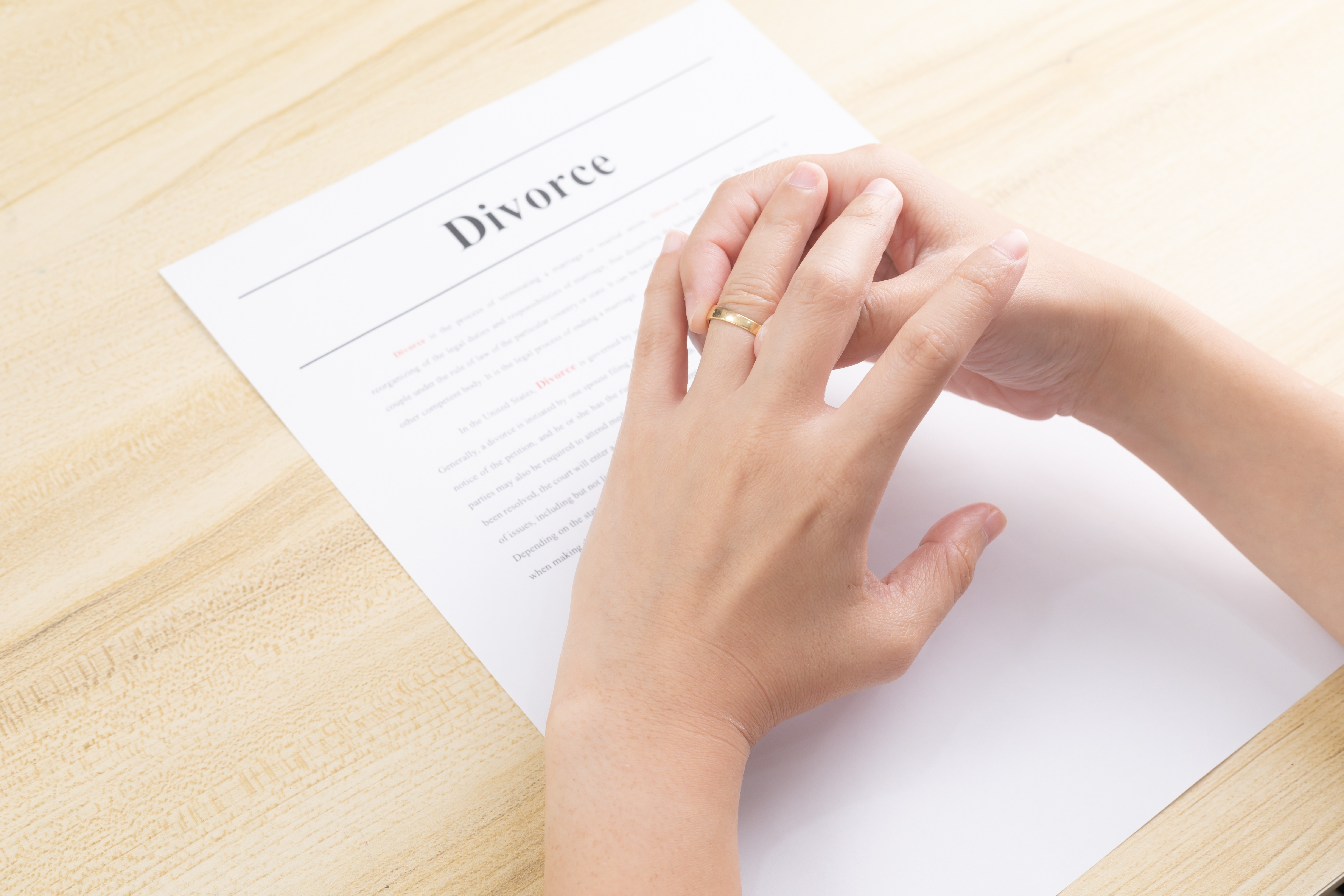 Eine Hand über den Scheidungspapieren | Quelle: Shutterstock