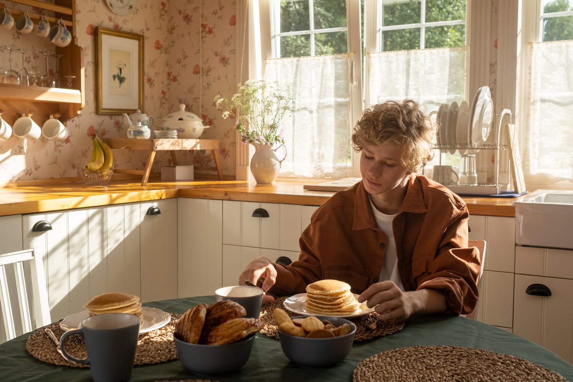 Ein Teenager sitzt am Küchentisch | Quelle: Pexels