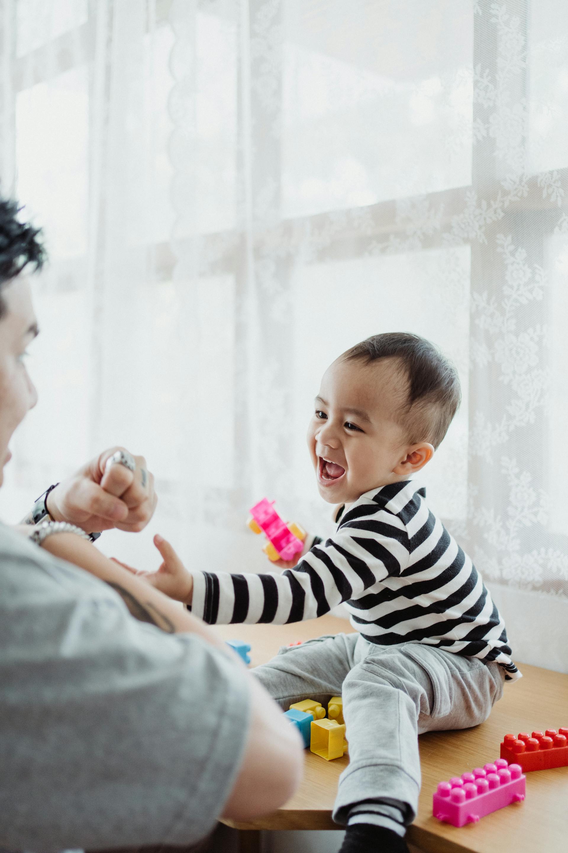 Ein Junge lacht beim Spielen mit seinem Vater | Quelle: Pexels