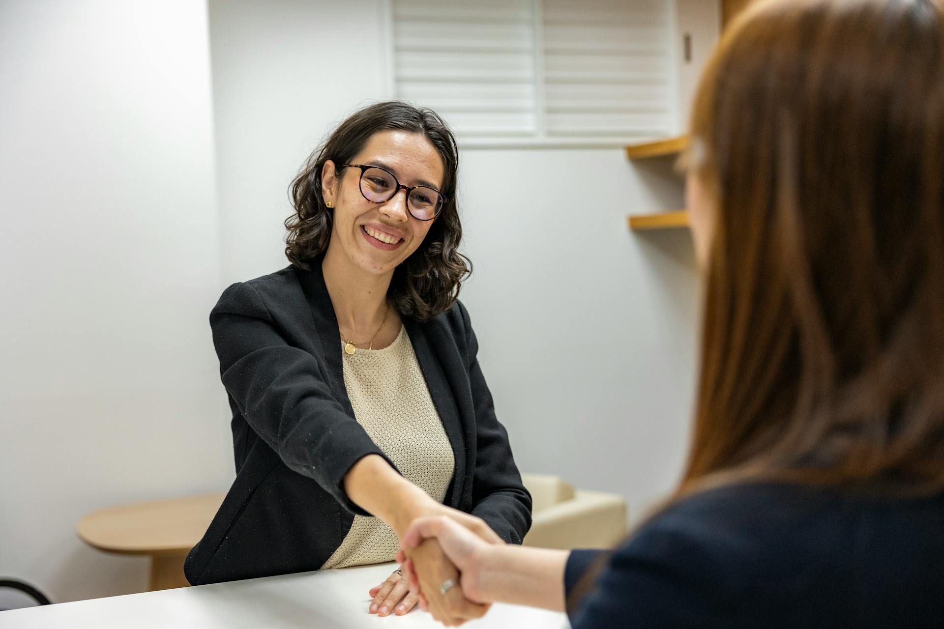 Frau beim Händeschütteln in einem Büro | Quelle: Pexels