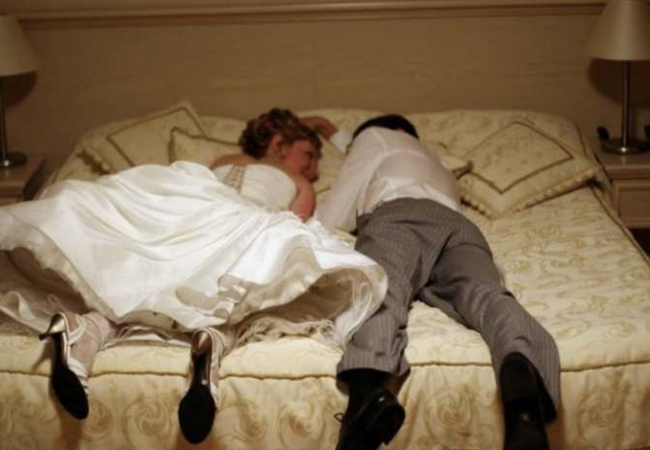 Frisch verheiratetes Paar auf einem Bett liegend | Quelle: Shutterstock