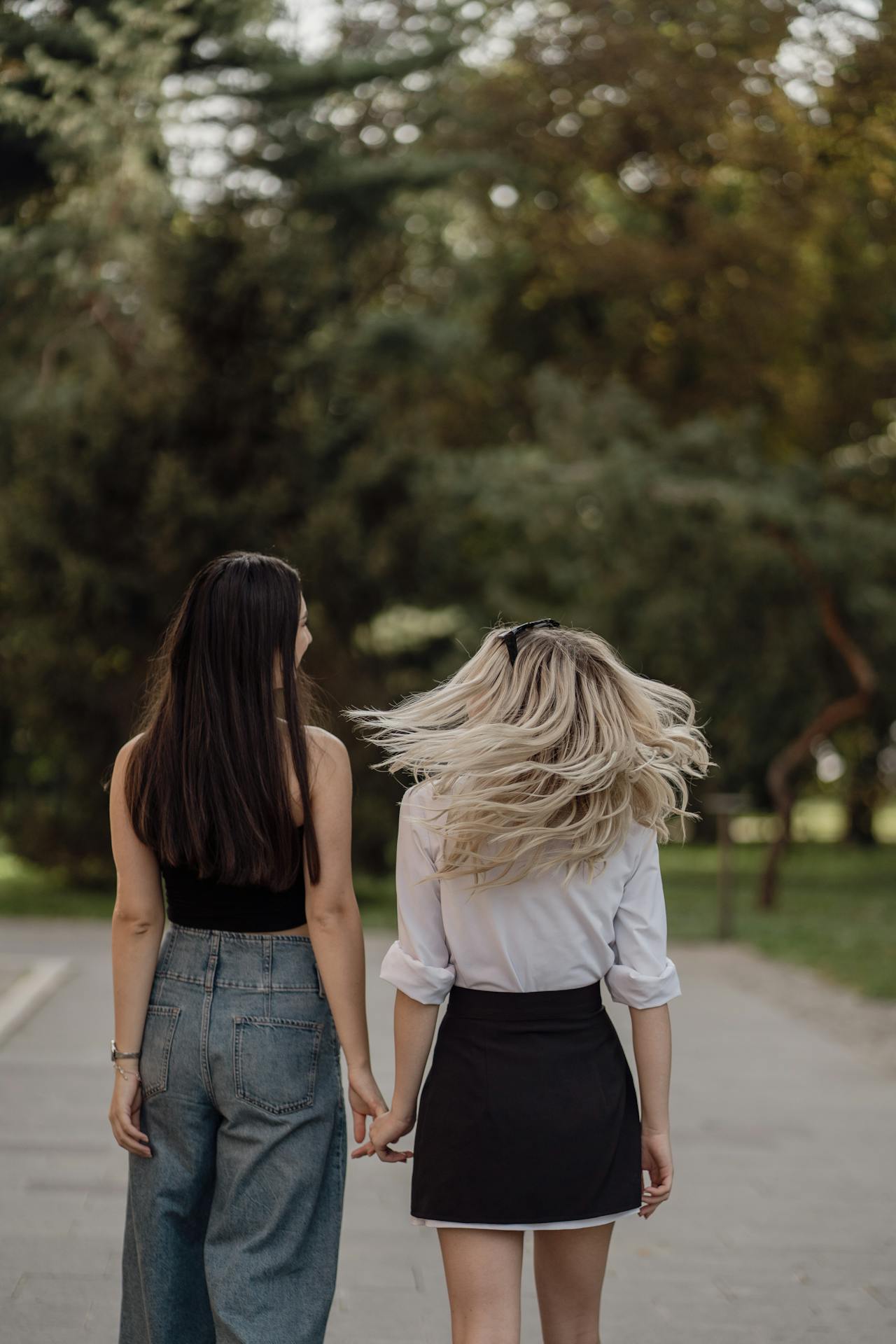 Zwei Frauen halten sich beim Gehen an den Händen | Quelle: Pexels