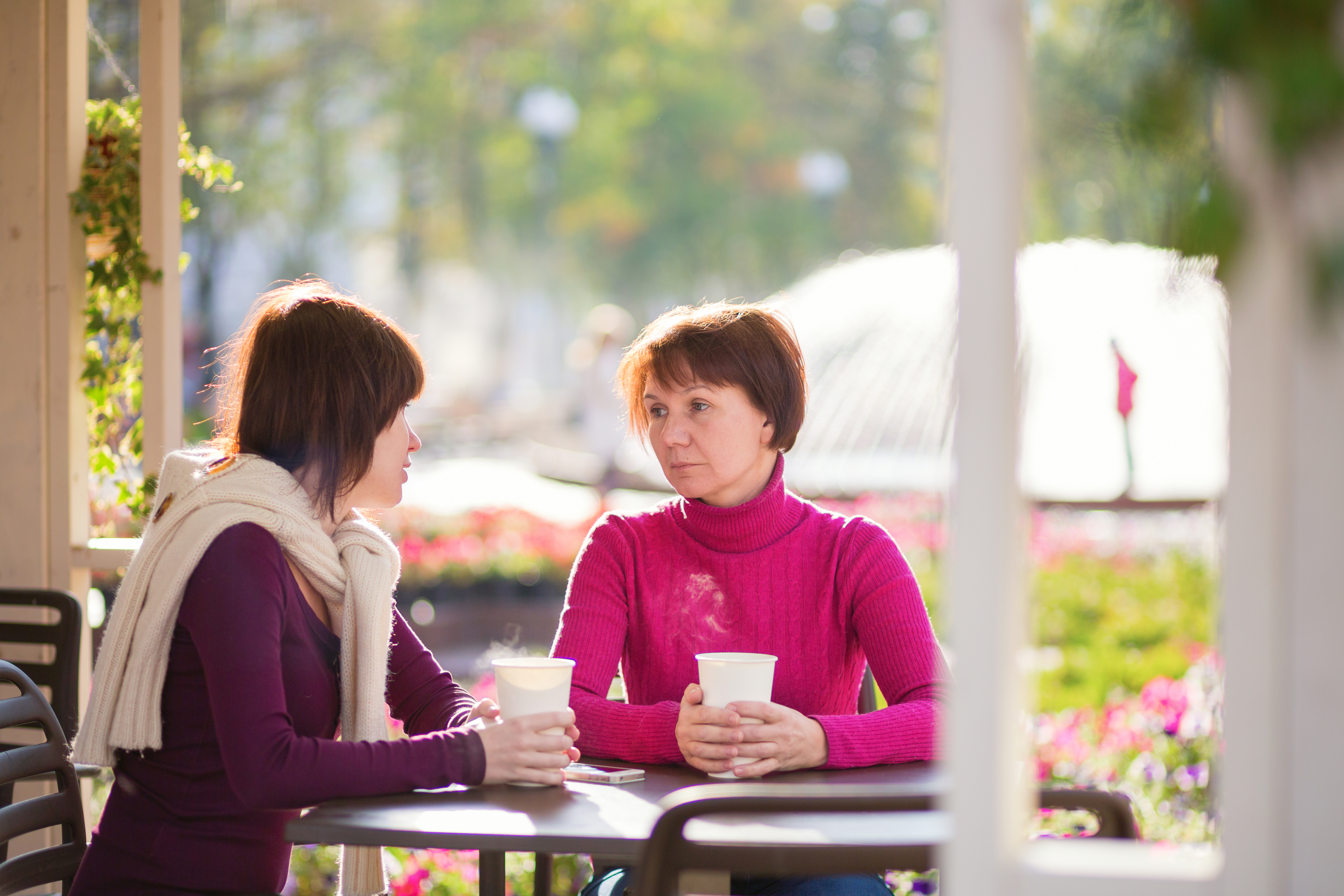 Eine junge Frau und eine ältere Frau sitzen in einem Cafe | Quelle: Shutterstock
