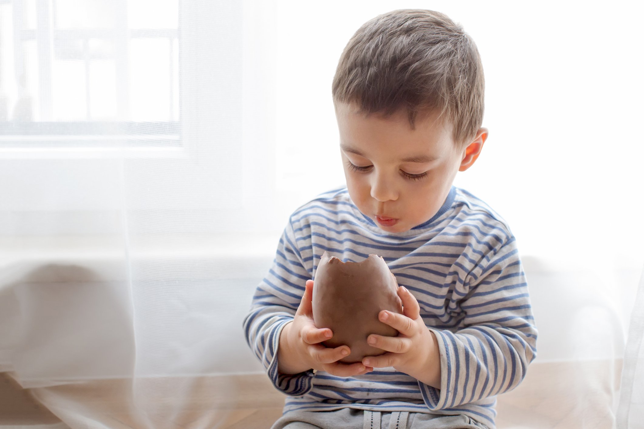 Junge, der ein großes Schokoladenosterei isst. I Quelle: Getty Images