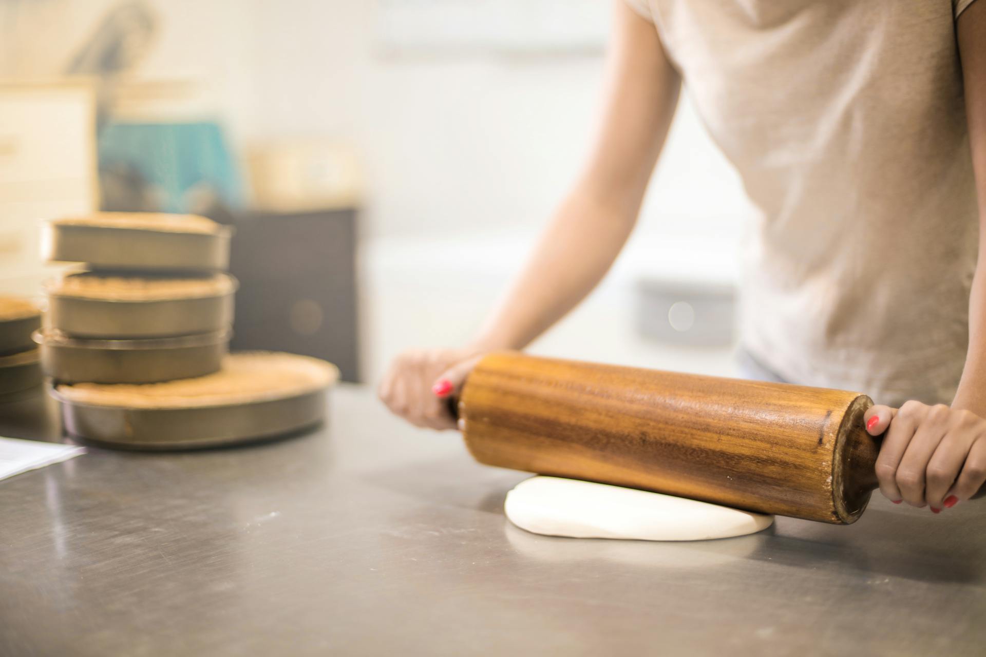 Eine Frau rollt Teig aus | Quelle: Pexels