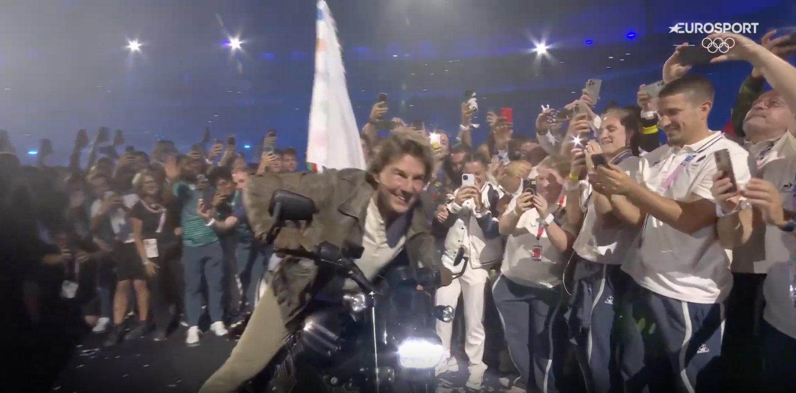 Tom Cruise beim Verlassen des Stadions mit der olympischen Flagge, aufgenommen am 12. August 2024 | Quelle: YouTube/Eurosport