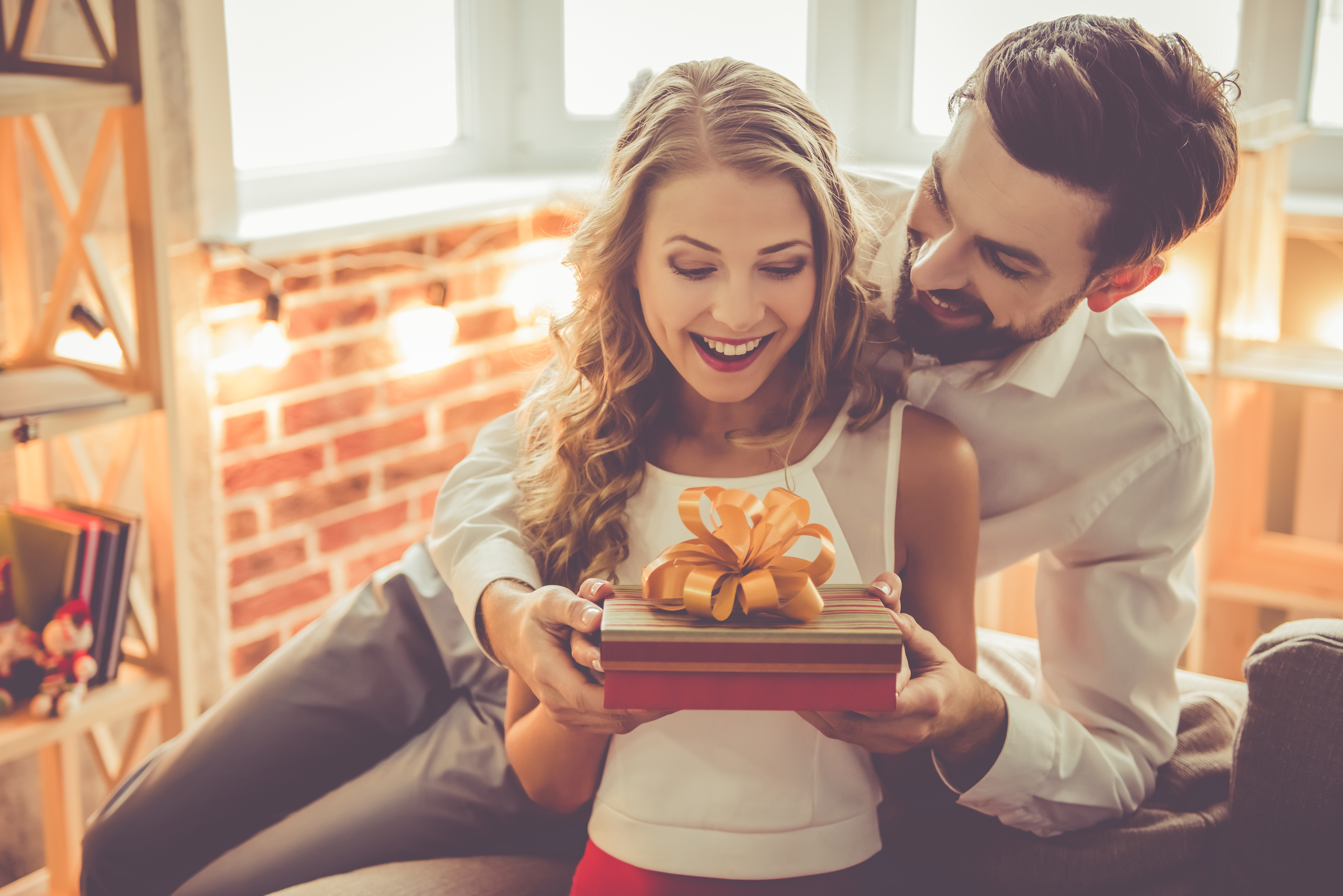 Ein junger Mann schenkt seiner Freundin eine Geschenkbox | Quelle: Shutterstock