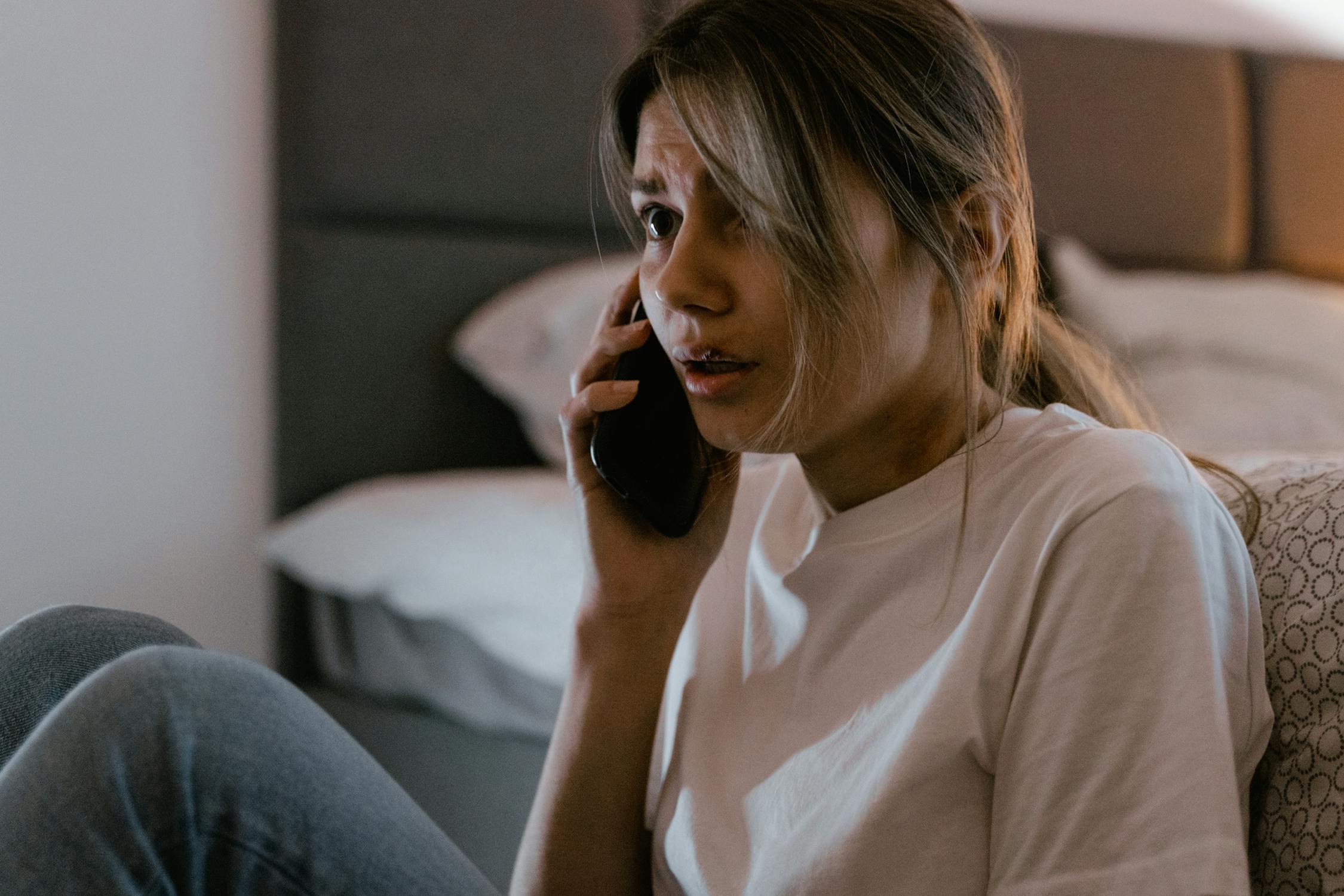 Eine verängstigte Frau, die auf ihrem Handy spricht | Quelle: Pexels