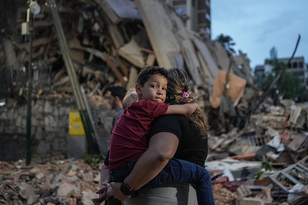 Menschen gehen am 25. Juni 2026 in Caracas an einem eingestürzten Gebäude vorbei, das durch ein Erdbeben zerstört wurde. Zwei starke Erdbeben hätten 32 Menschen das Leben gekostet und mehr als 700 verletzt, erklärte der Interimspräsident des Landes am 25. Juni, nachdem die massiven Erschütterungen ganze Gebäude zum Einsturz gebracht und die Menschen in Panik in die Flucht getrieben hatten. | Quelle: Getty Images
