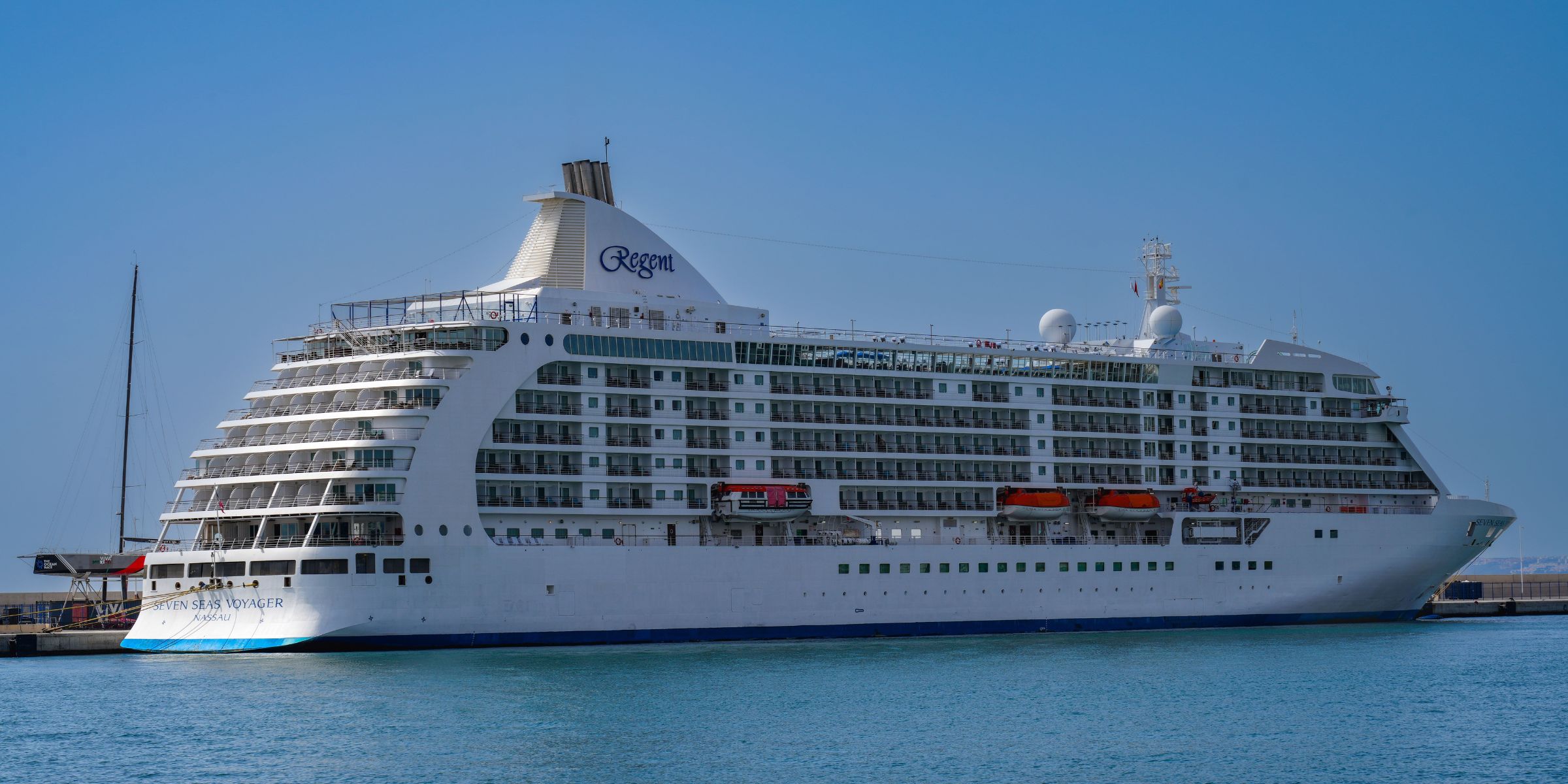 Ein Luxuskreuzfahrtschiff liegt in einem sonnigen Hafen vor Anker | Quelle: Pexels