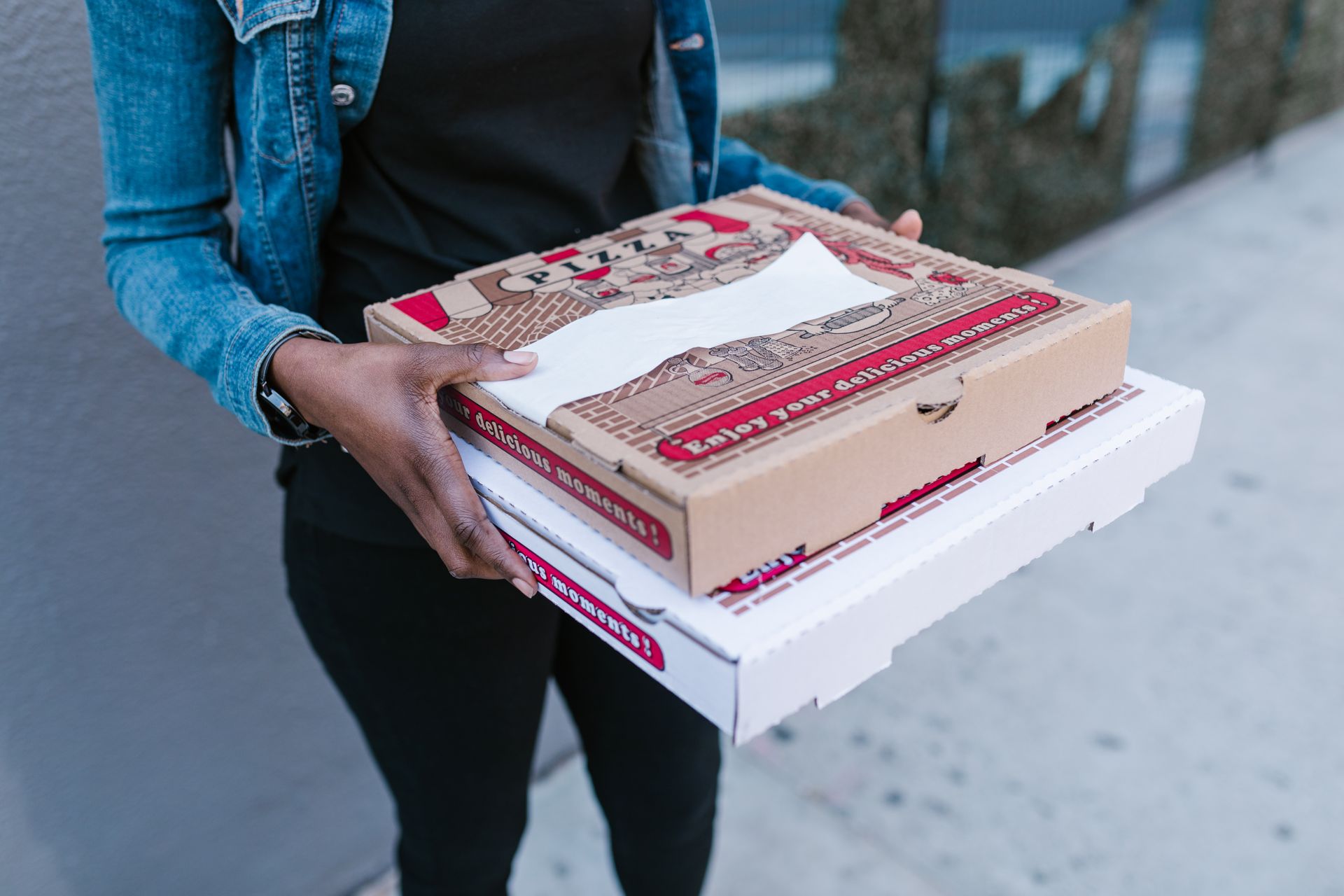 Eine Frau, die Pizzakartons in der Hand hält | Quelle: Pexels