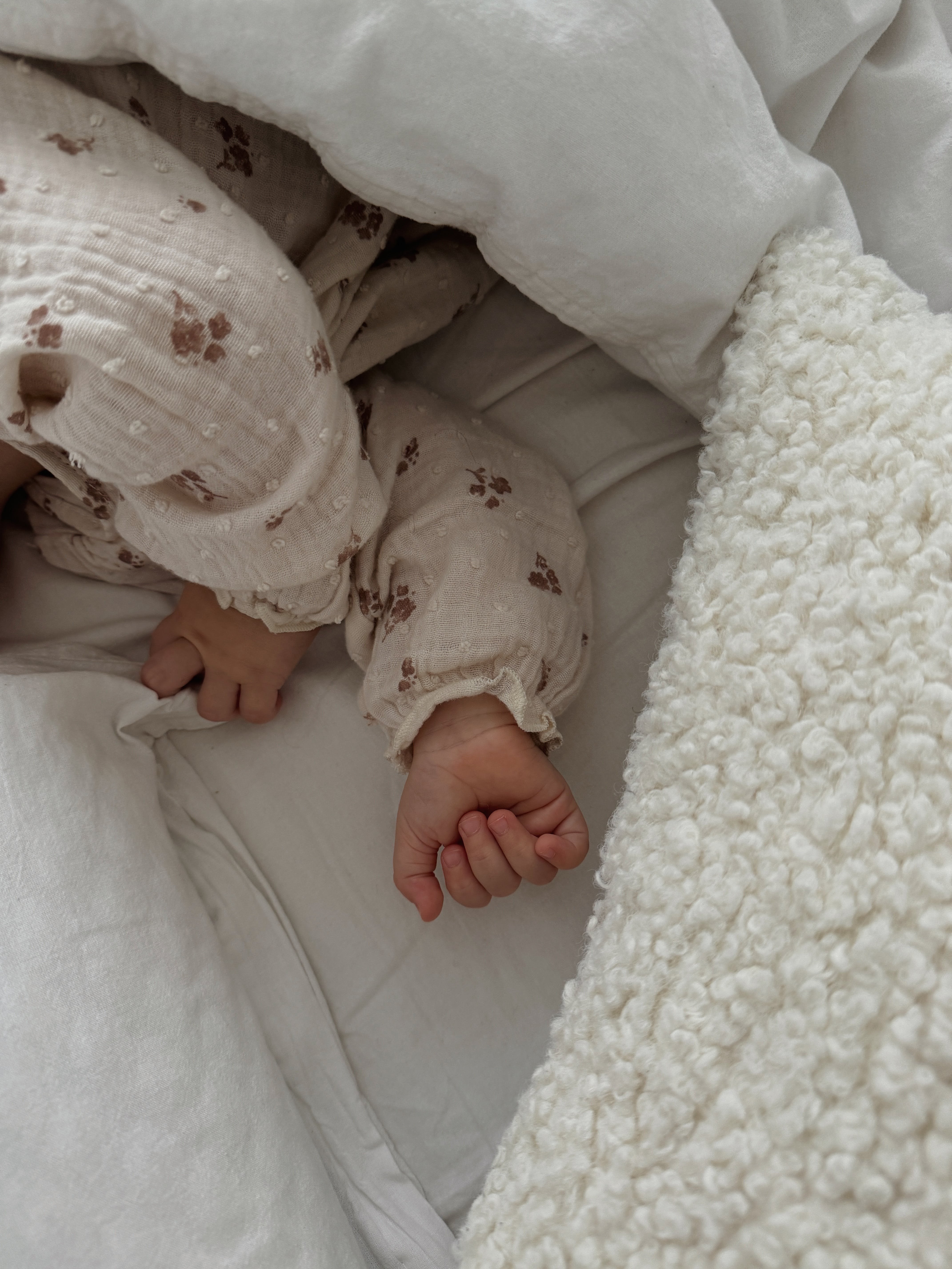 Die Hände eines Babys, das in einem Kinderbettchen schläft | Quelle: Pexels