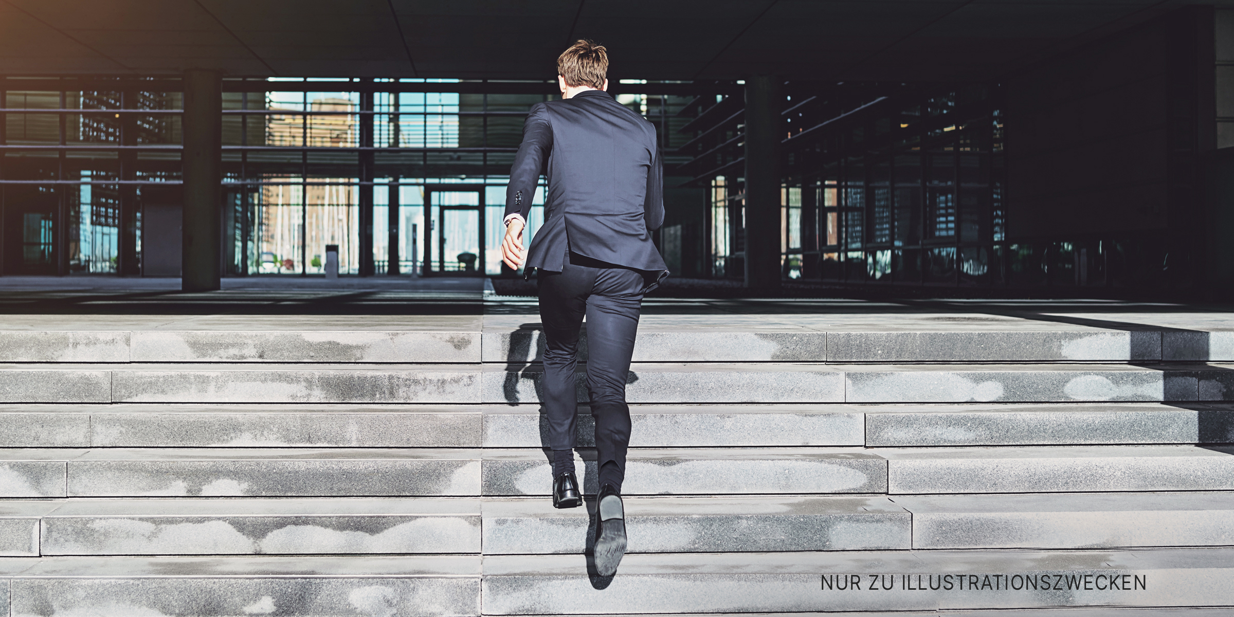 Mann im Anzug läuft eine Treppe hinauf | Quelle: Shutterstock