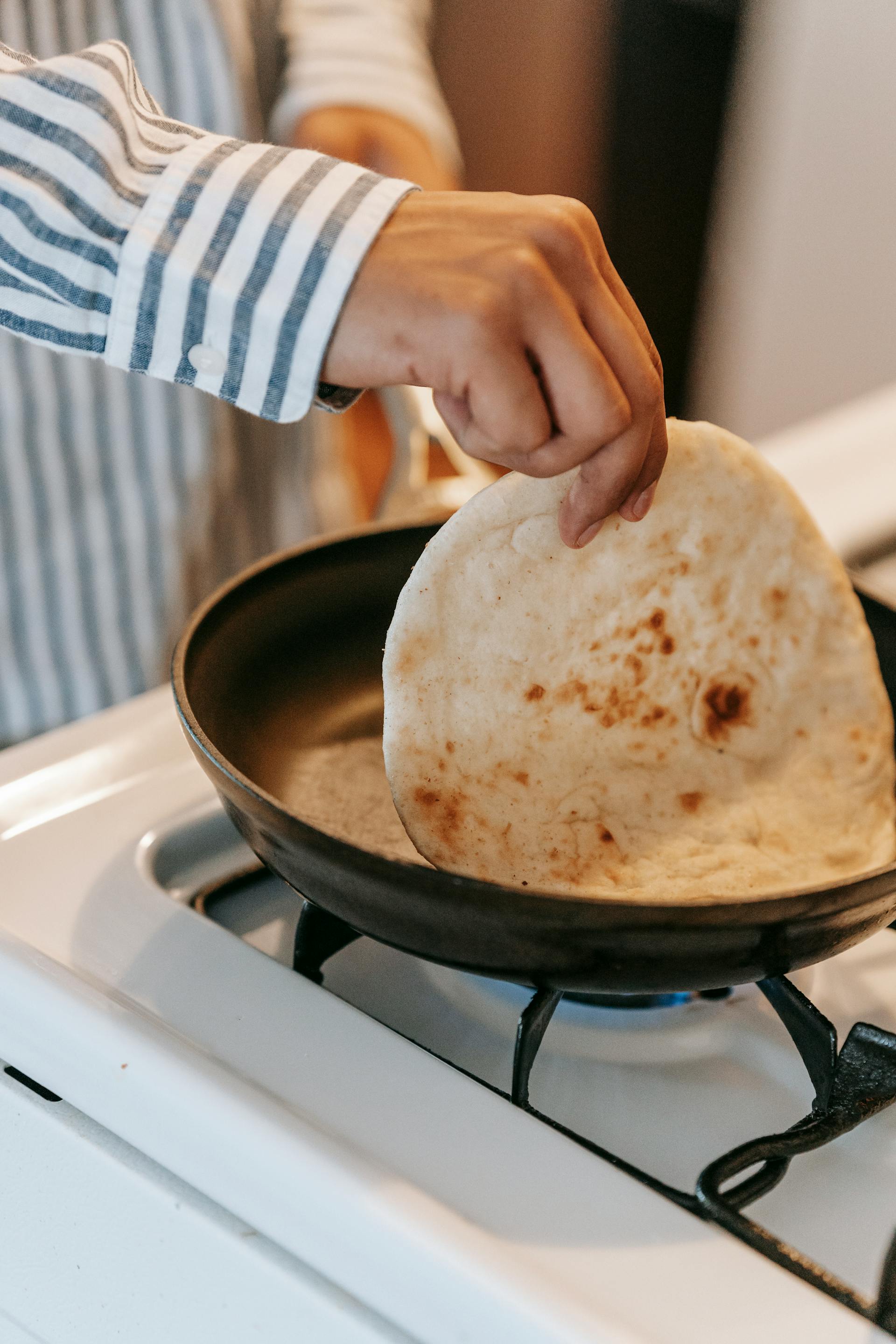 Ein Mann, der in der Küche Fladenbrot backt | Quelle: Pexels