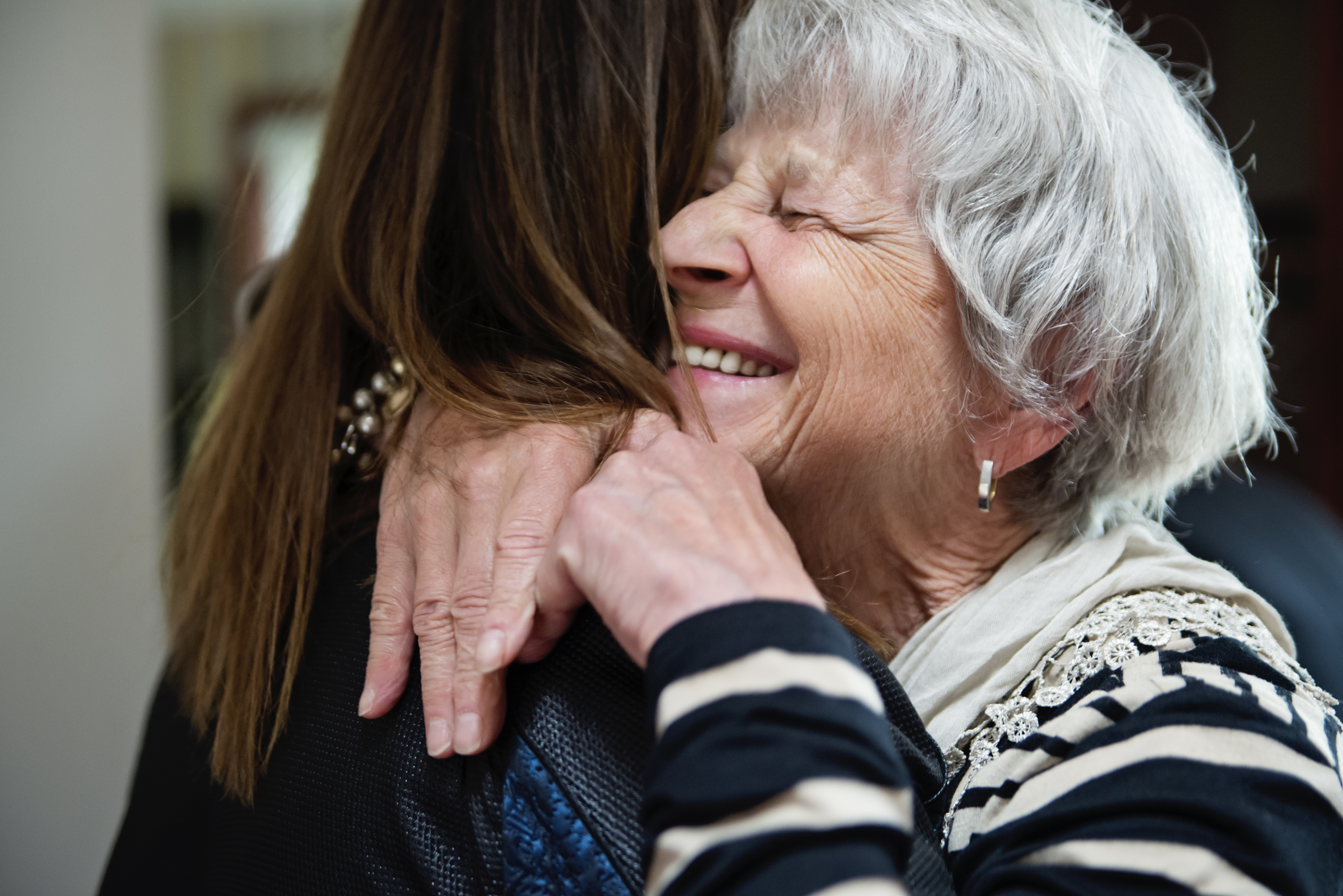 Ältere Großmutter und erwachsene Enkeltochter umarmen sich | Quelle: Getty Images
