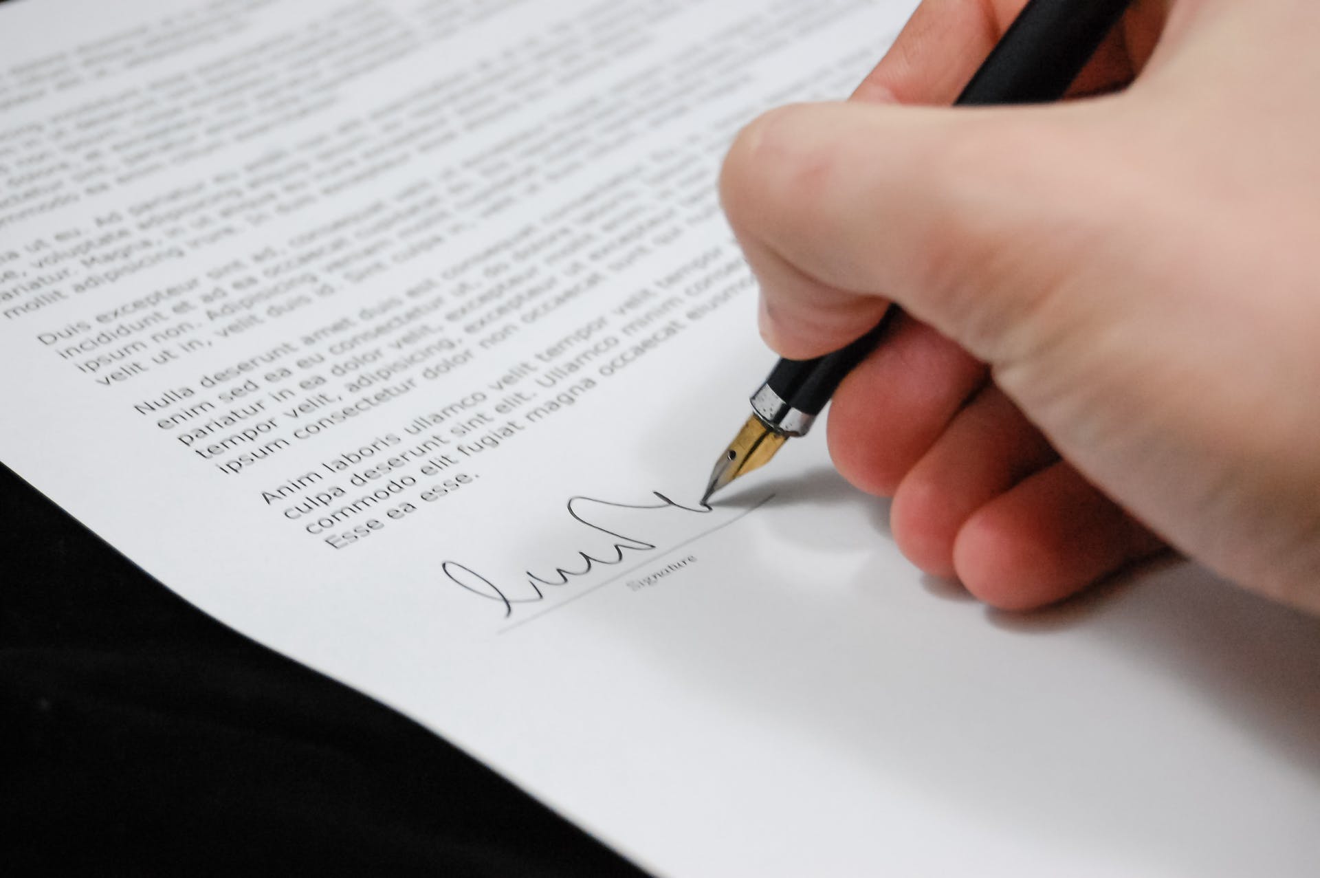 Person, die ein juristisches Dokument unterzeichnet | Quelle: Pexels