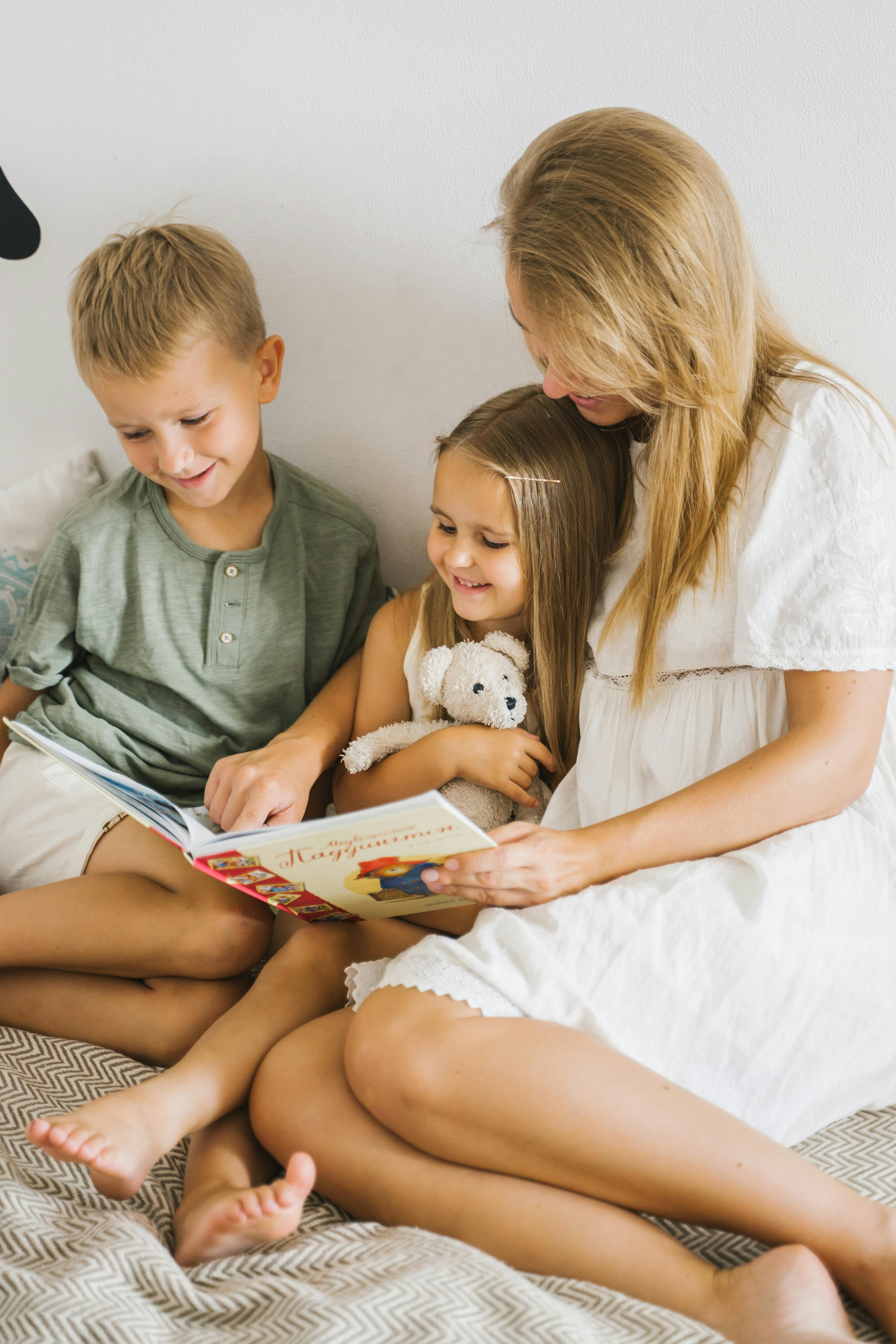 Eine Frau liest zwei Kindern ein Buch vor | Quelle: Pexels