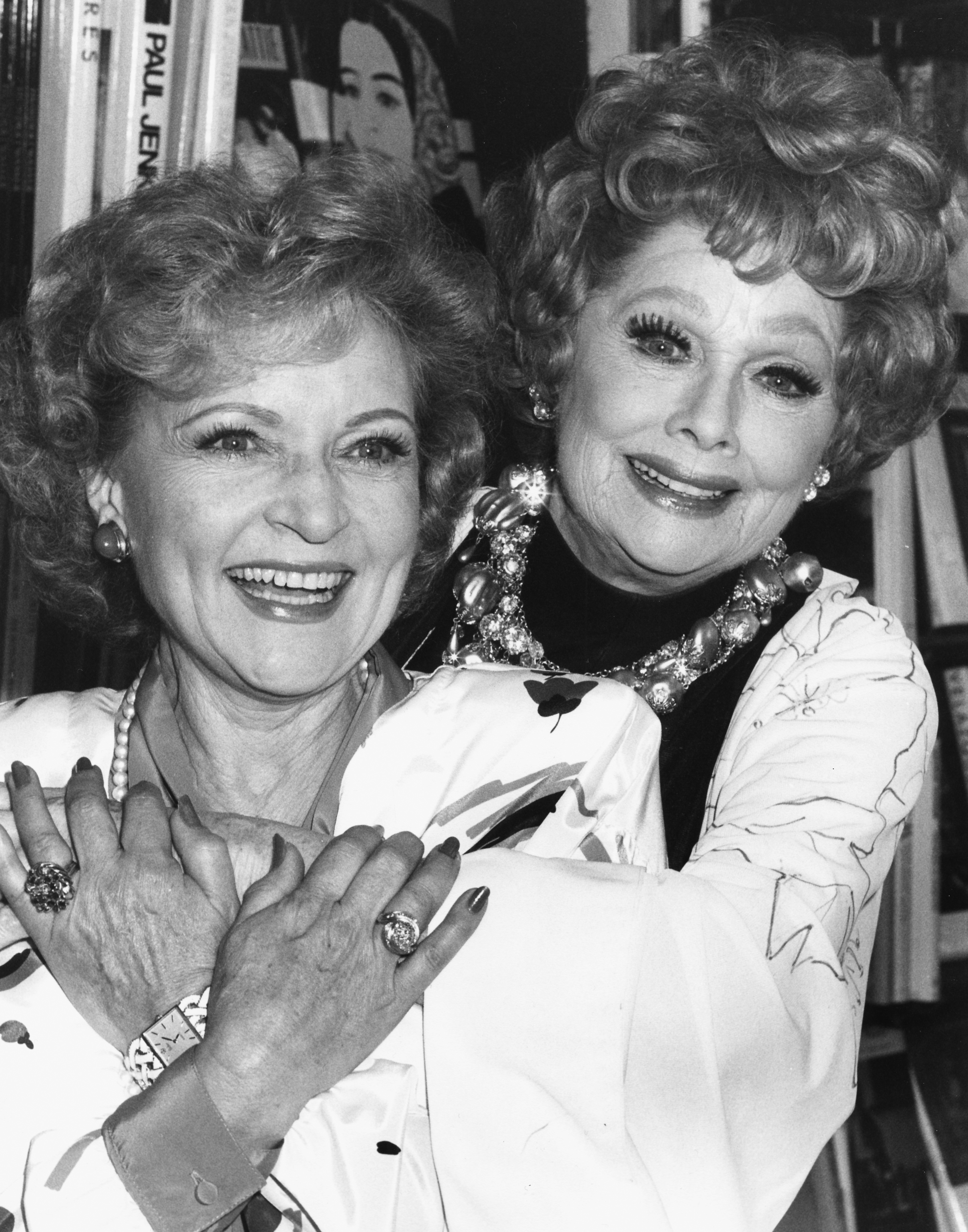 Betty White und Lucille Ball umarmen sich bei einer Buchsignierstunde am 2. Oktober 1987 in Los Angeles, Kalifornien. | Quelle: Getty Images