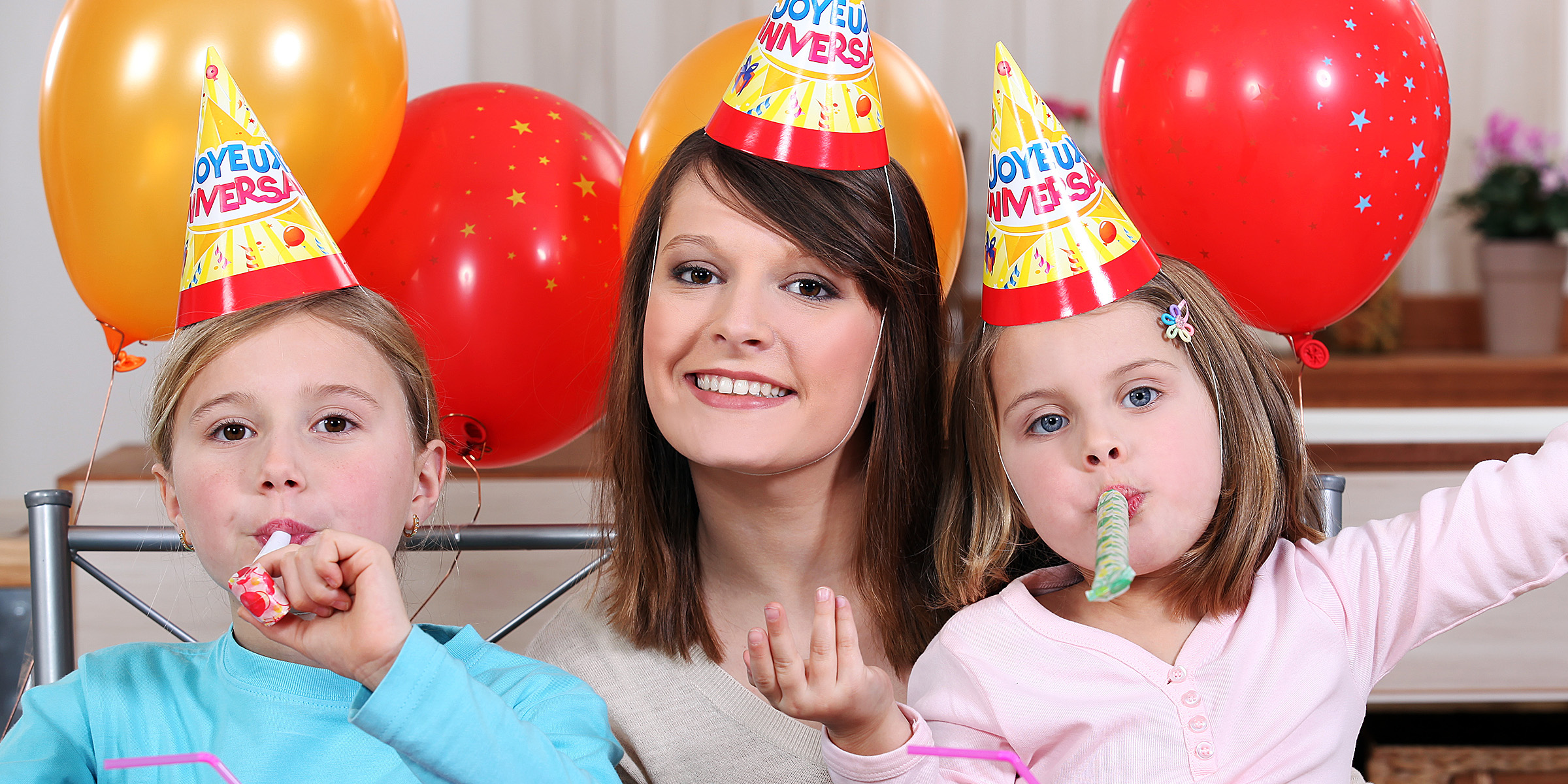 Eine Frau mit zwei Kindern auf einer Geburtstagsparty | Quelle: Shutterstock