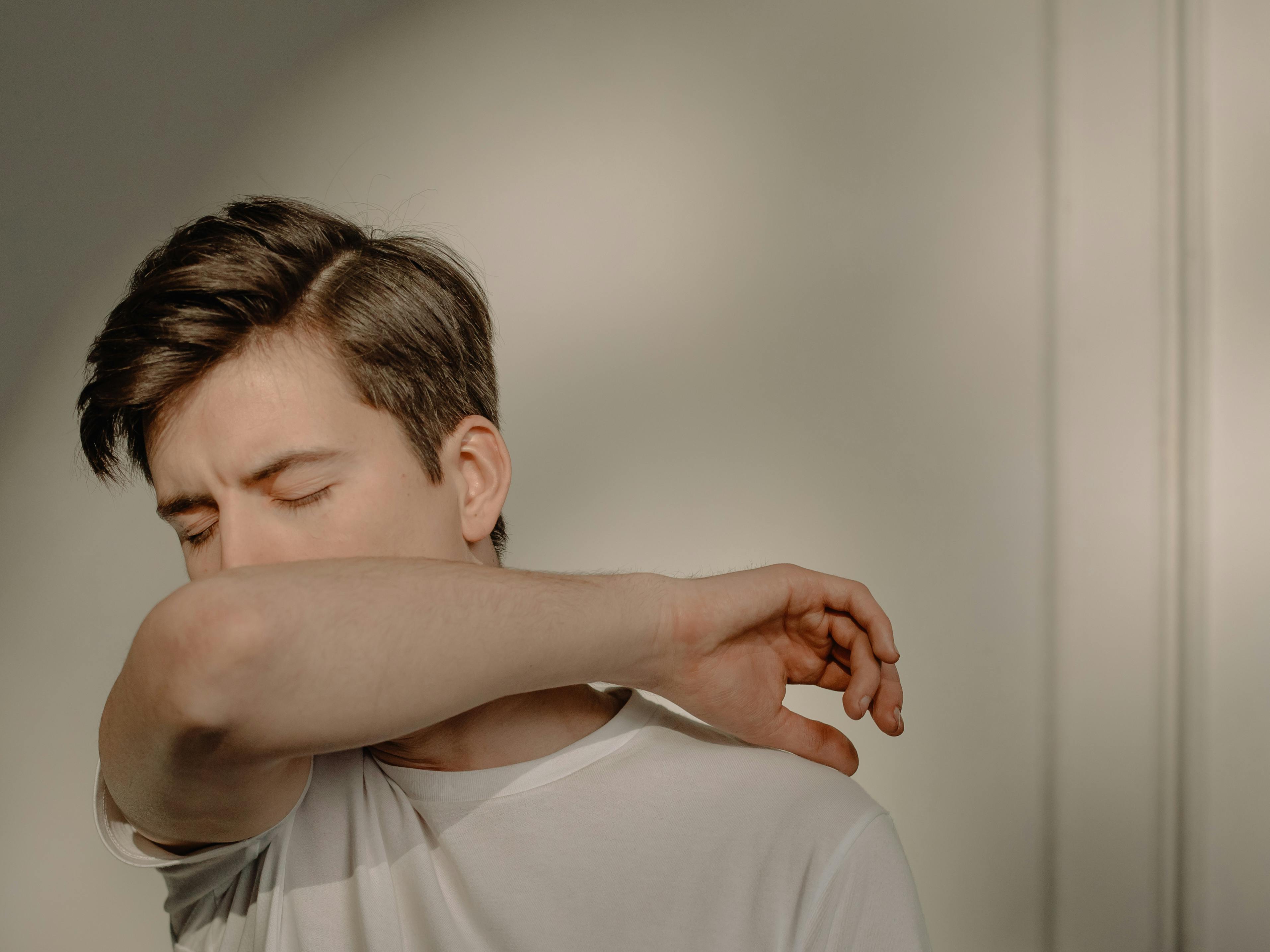 Ein Mann, der in seinen Arm hustet | Quelle: Pexels