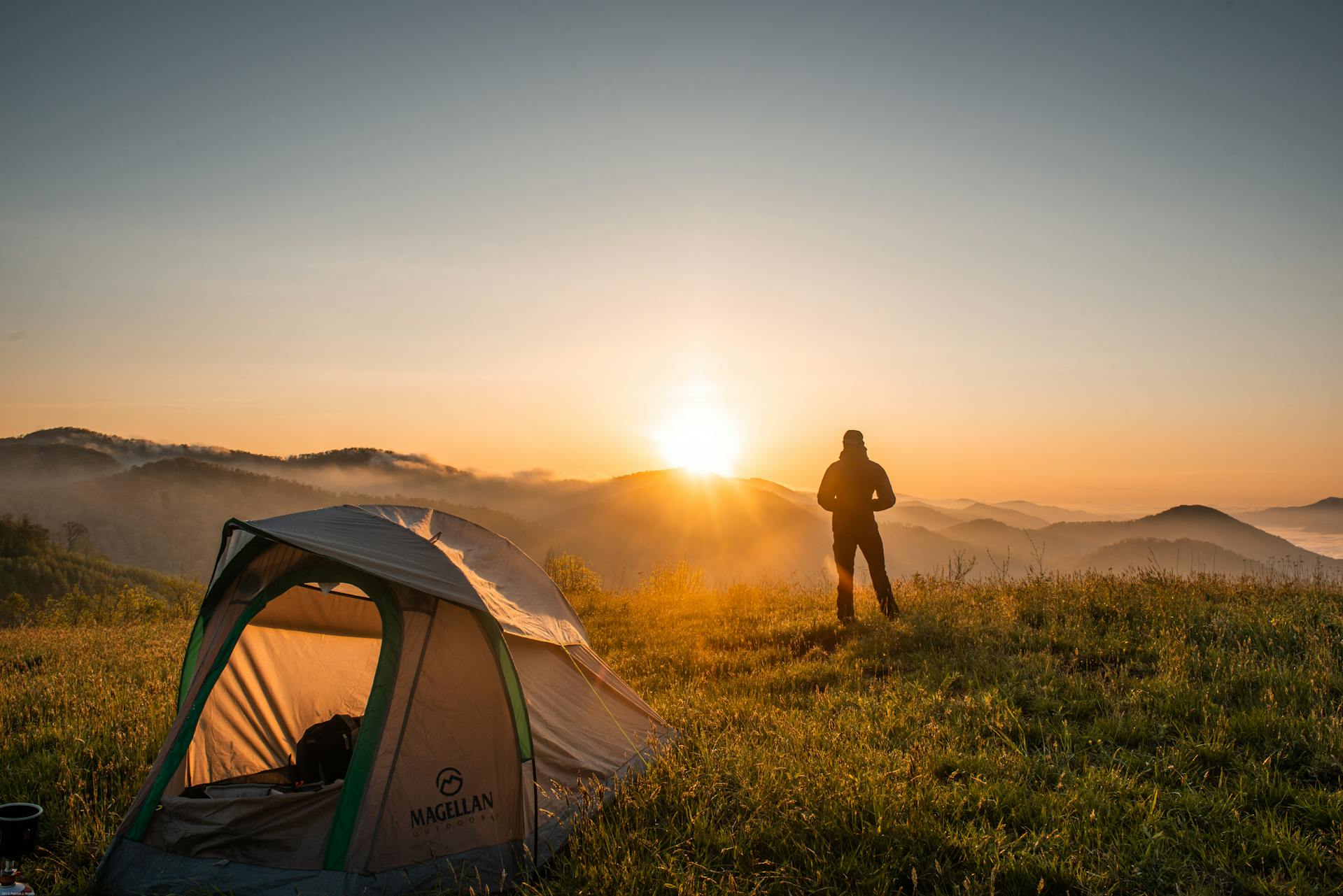 Eine Person steht in der Nähe eines Campingzeltes | Quelle: Pexels