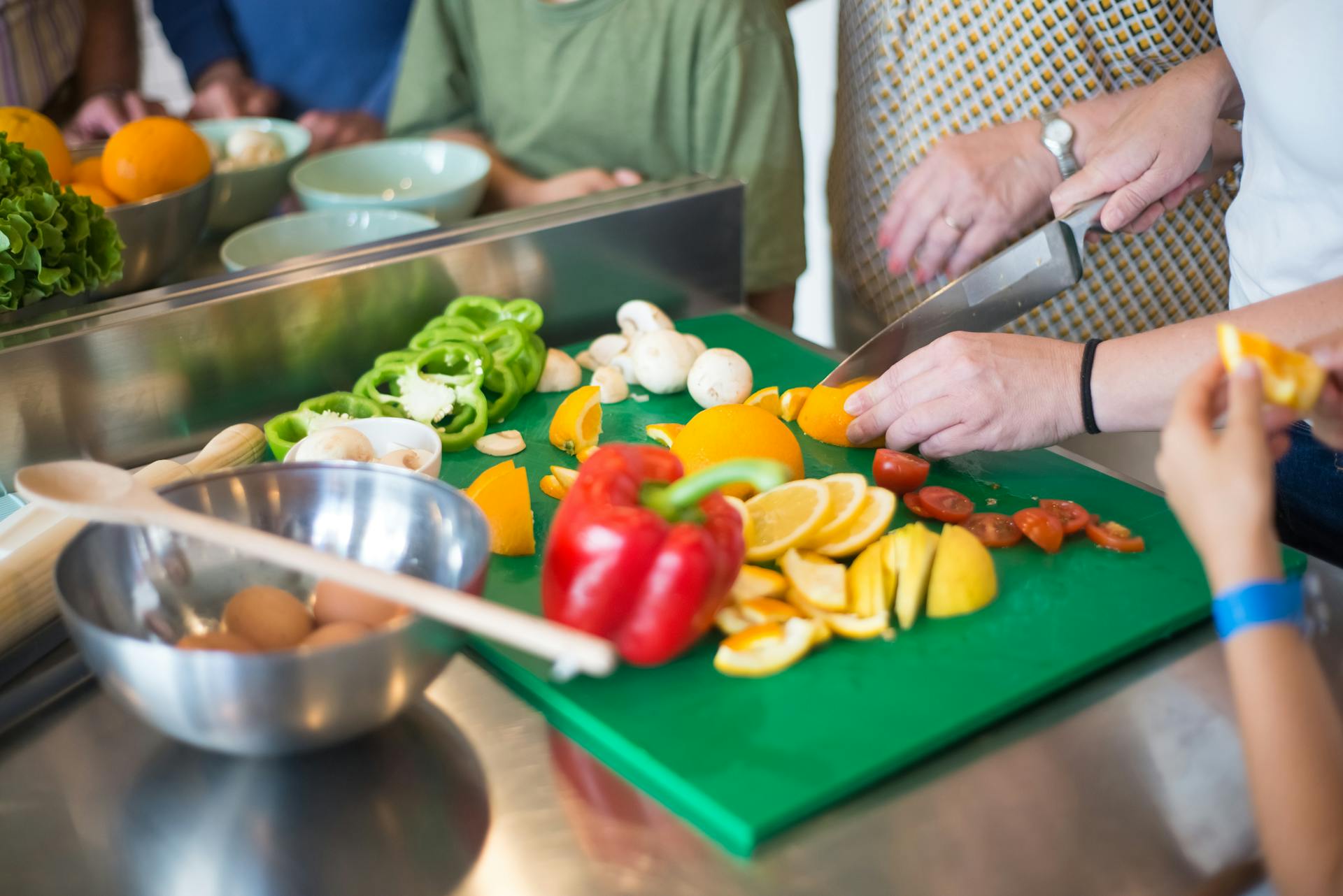 Eine Nahaufnahme von Familienmitgliedern, die in der Küche Essen zubereiten | Quelle: Pexels