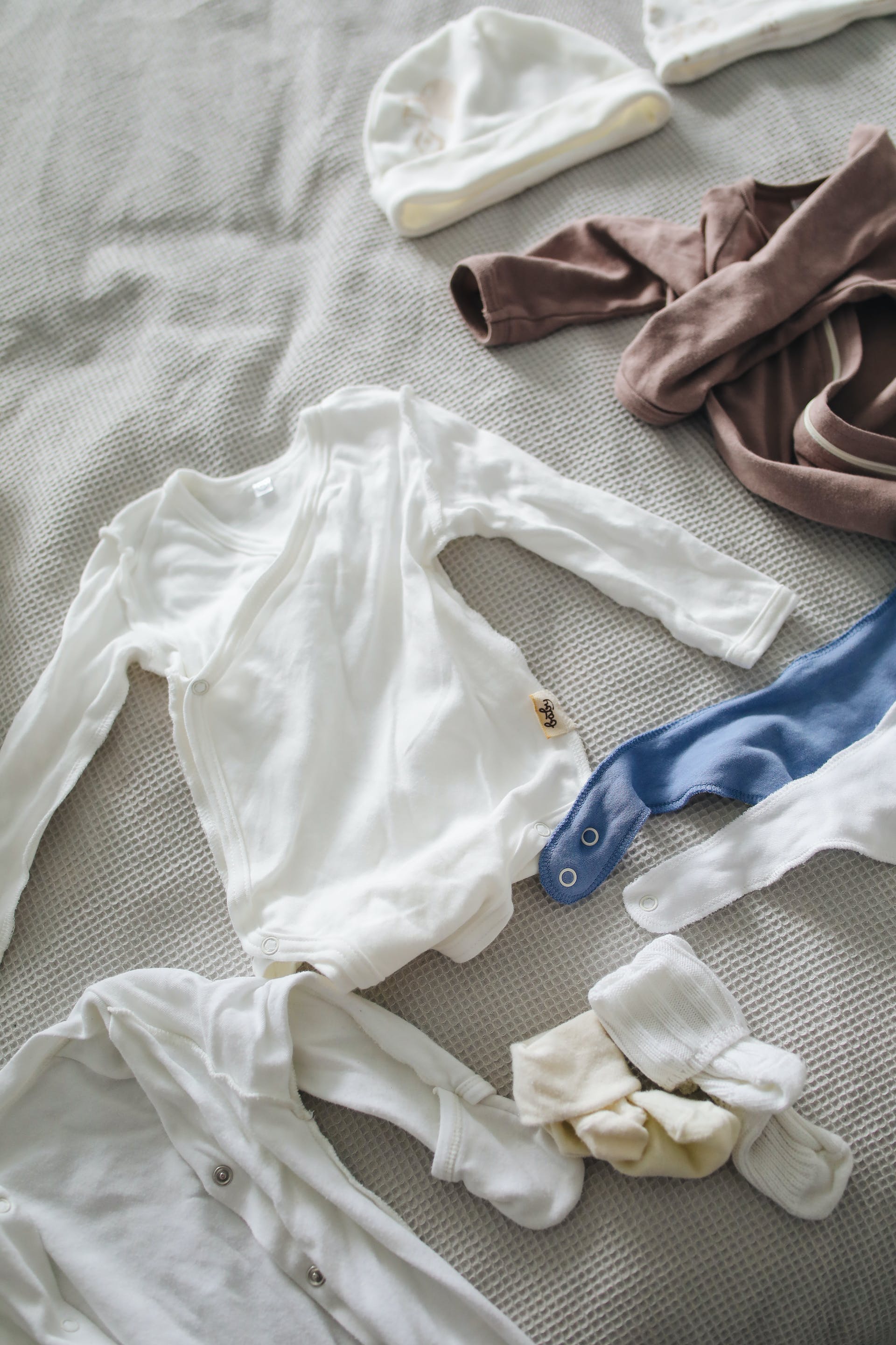 Auf einer Fläche ausgelegte Babykleidung | Quelle: Pexels