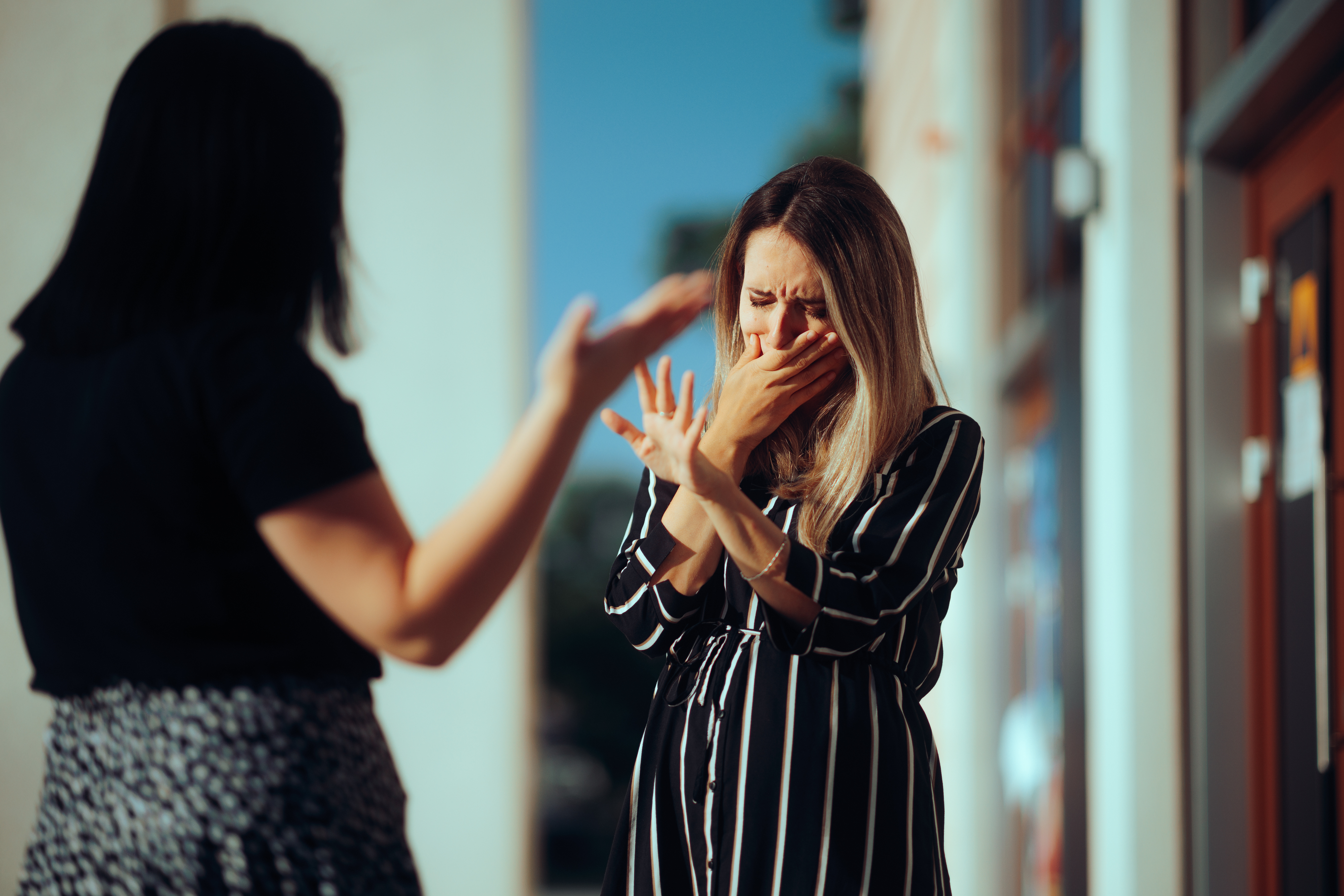 Weinende Frau streitet sich mit ihrer besten Freundin im Freien | Quelle: Getty Images