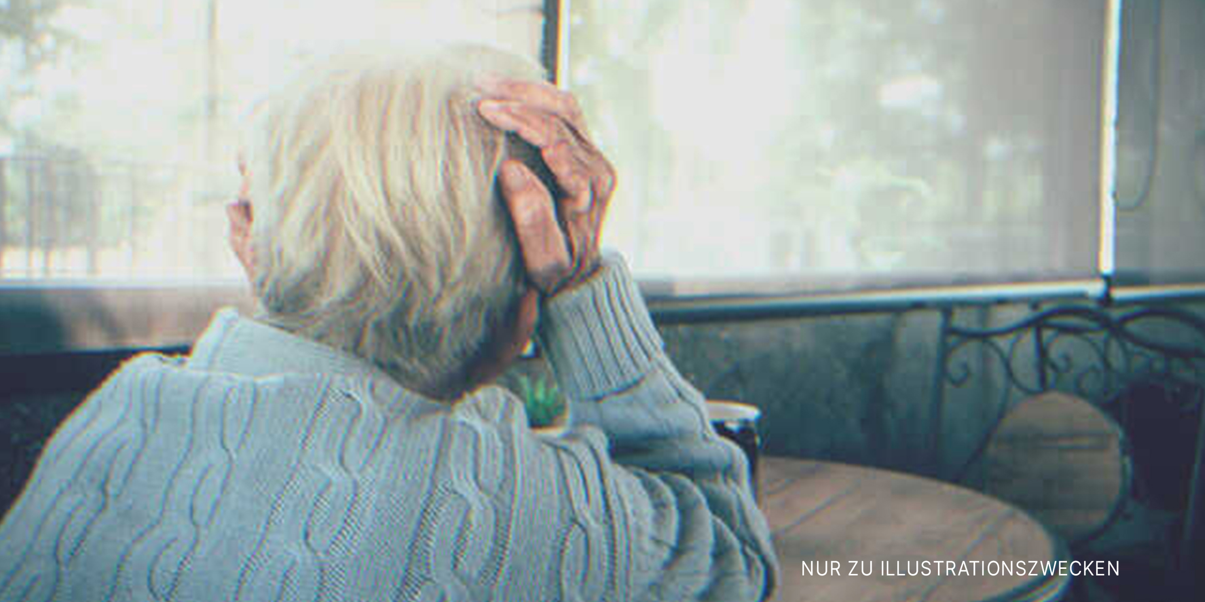 Alte Frau am Tisch | Quelle: Shutterstock
