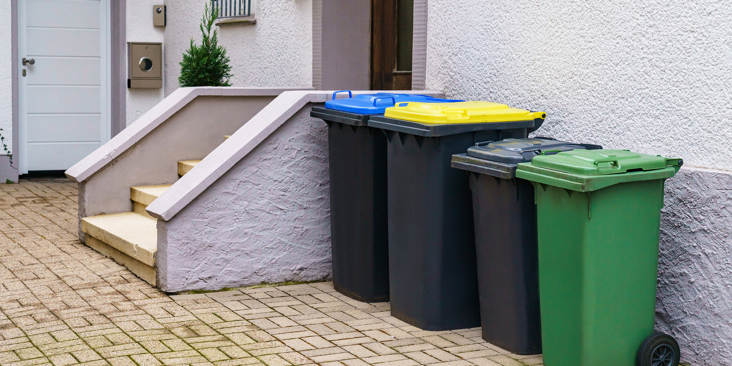 Mülltonnen vor einem Haus | Quelle: Shutterstock