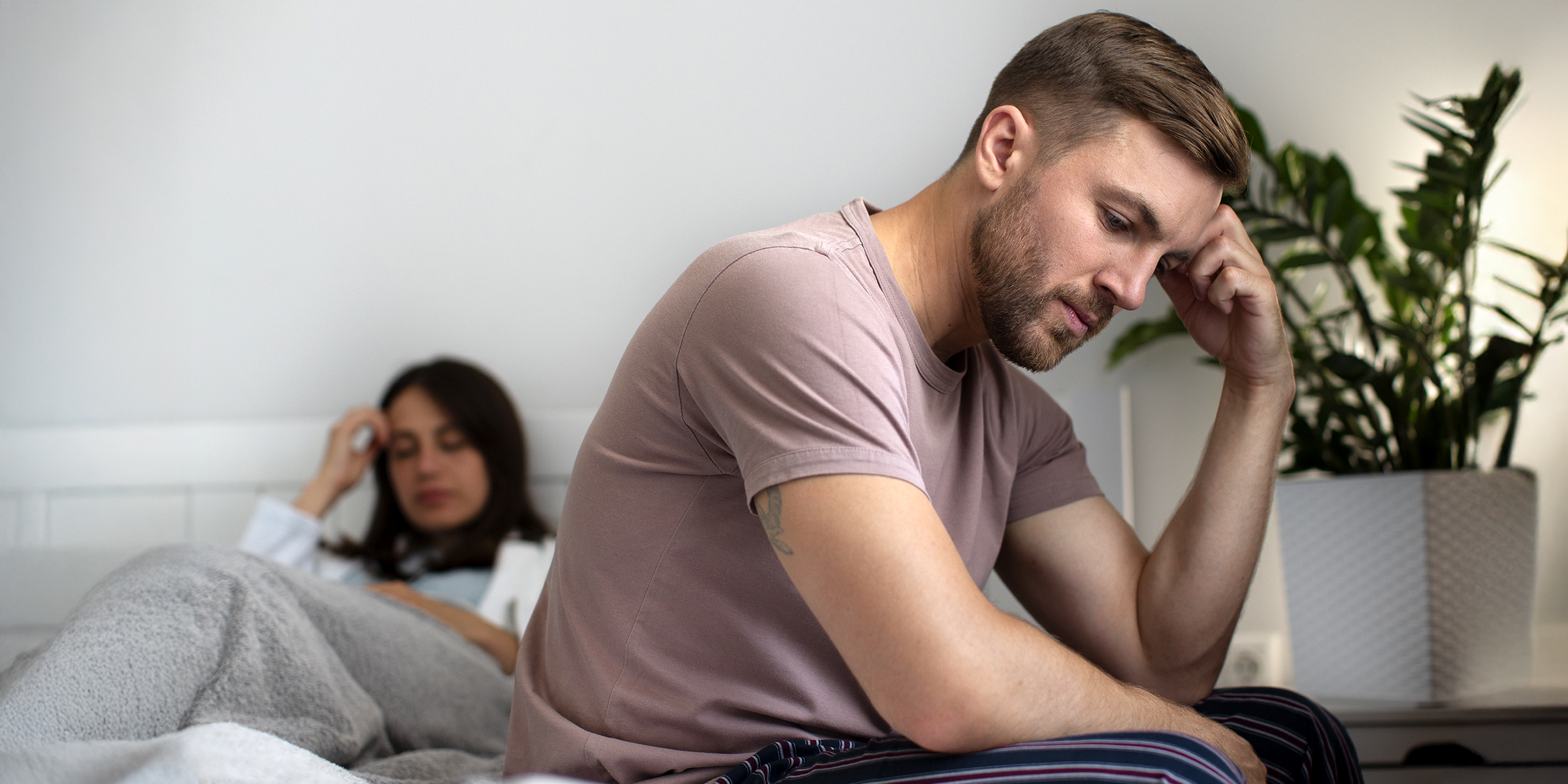 Ein aufgebrachtes Paar sitzt auf einem Bett | Quelle: Freepik