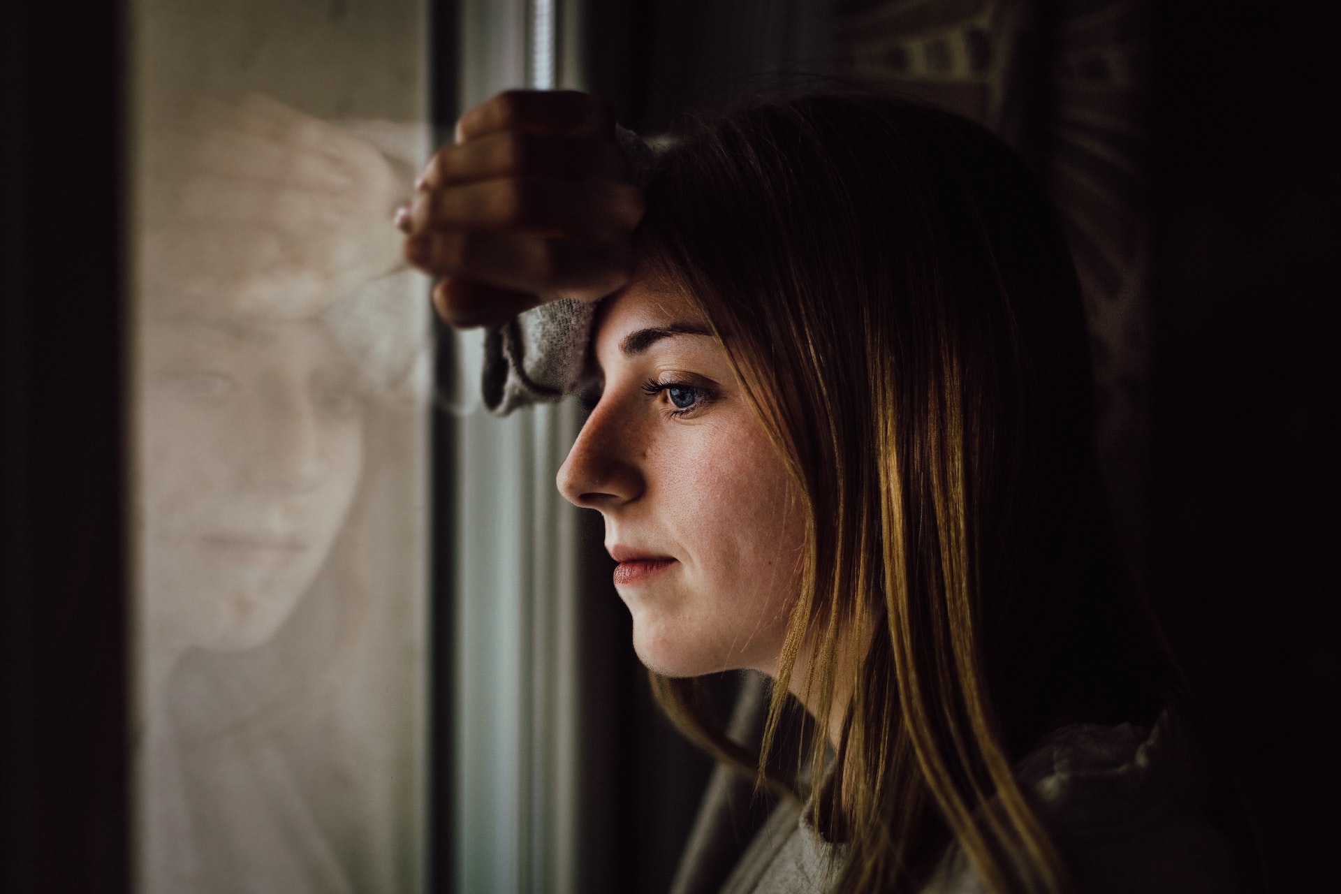 Eine Frau, die aus einem Fenster schaut | Quelle: Pexels