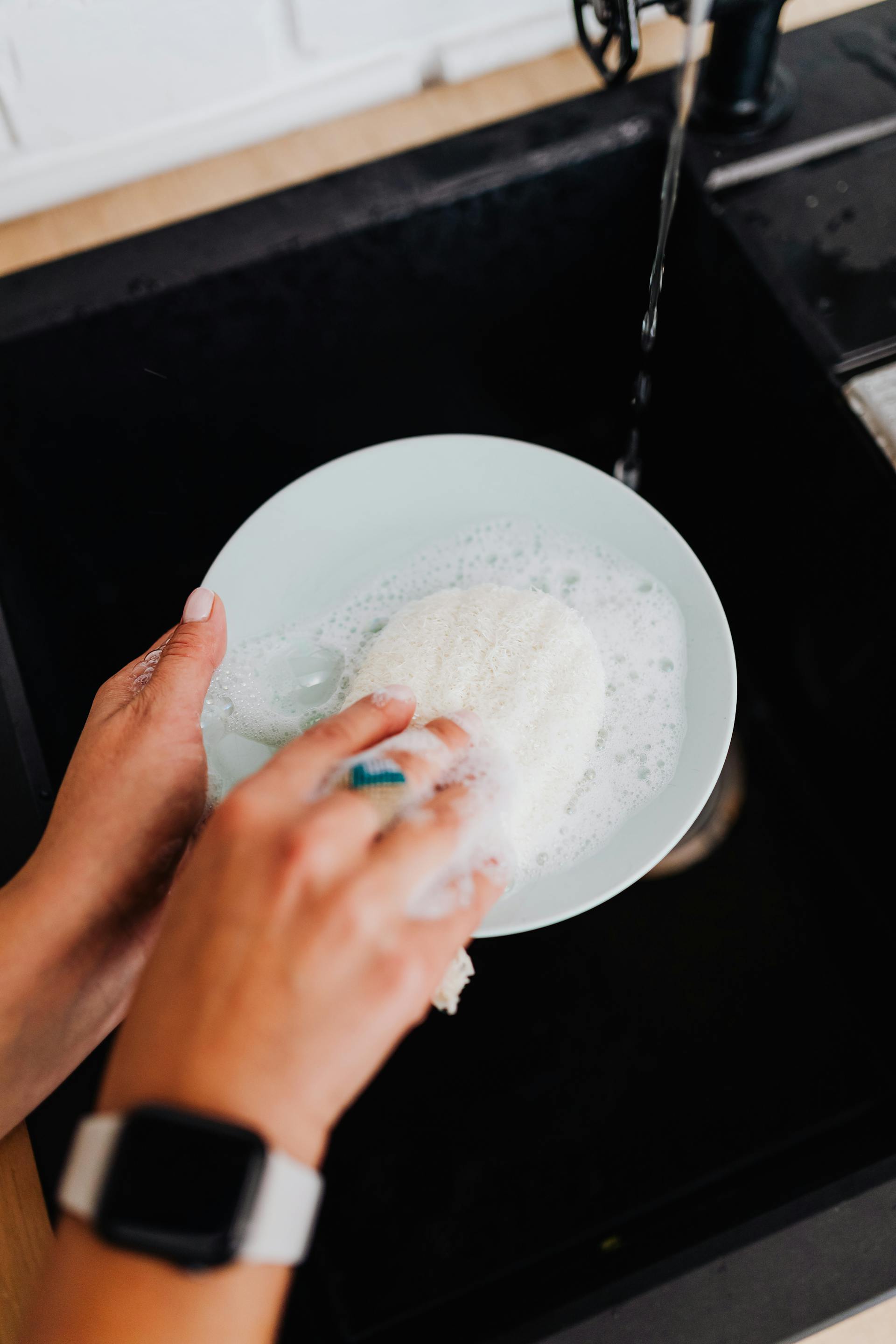 Eine Person beim Geschirrspülen | Quelle: Pexels