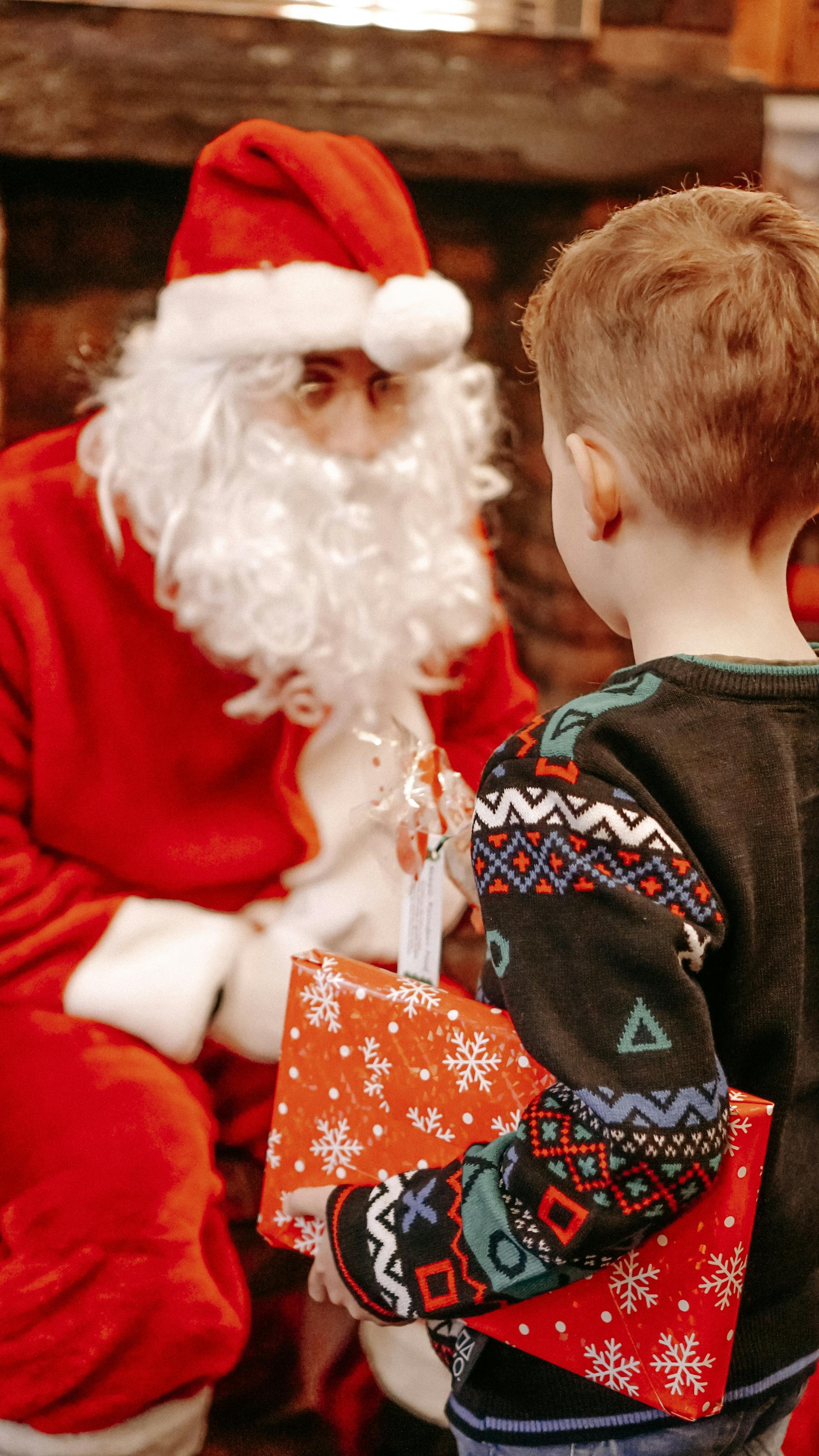 Ein kleiner Junge erhält ein Geschenk vom Weihnachtsmann an Weihnachten | Quelle: Pexels