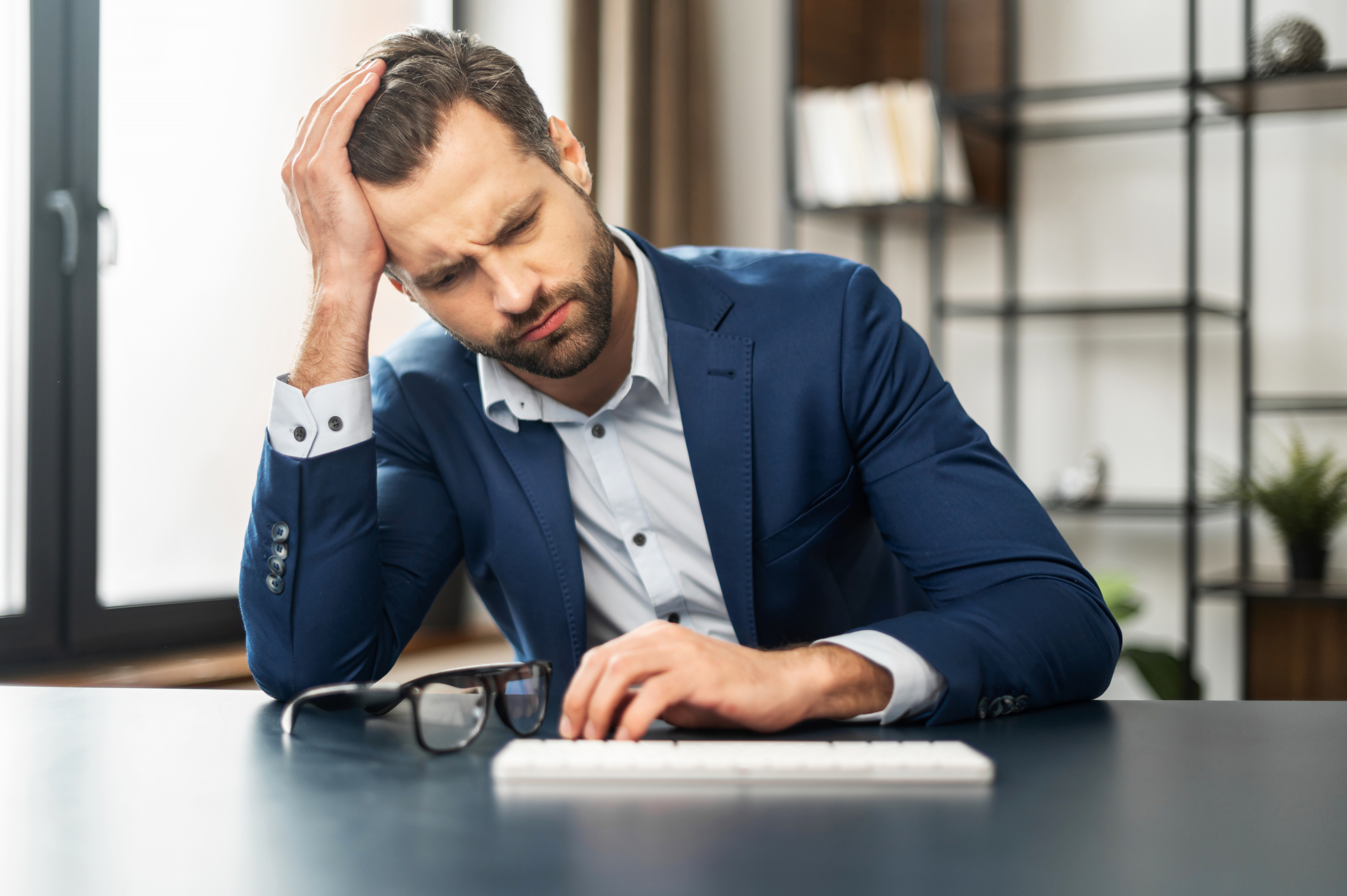 Mann gestresst bei der Arbeit | Quelle: Shutterstock