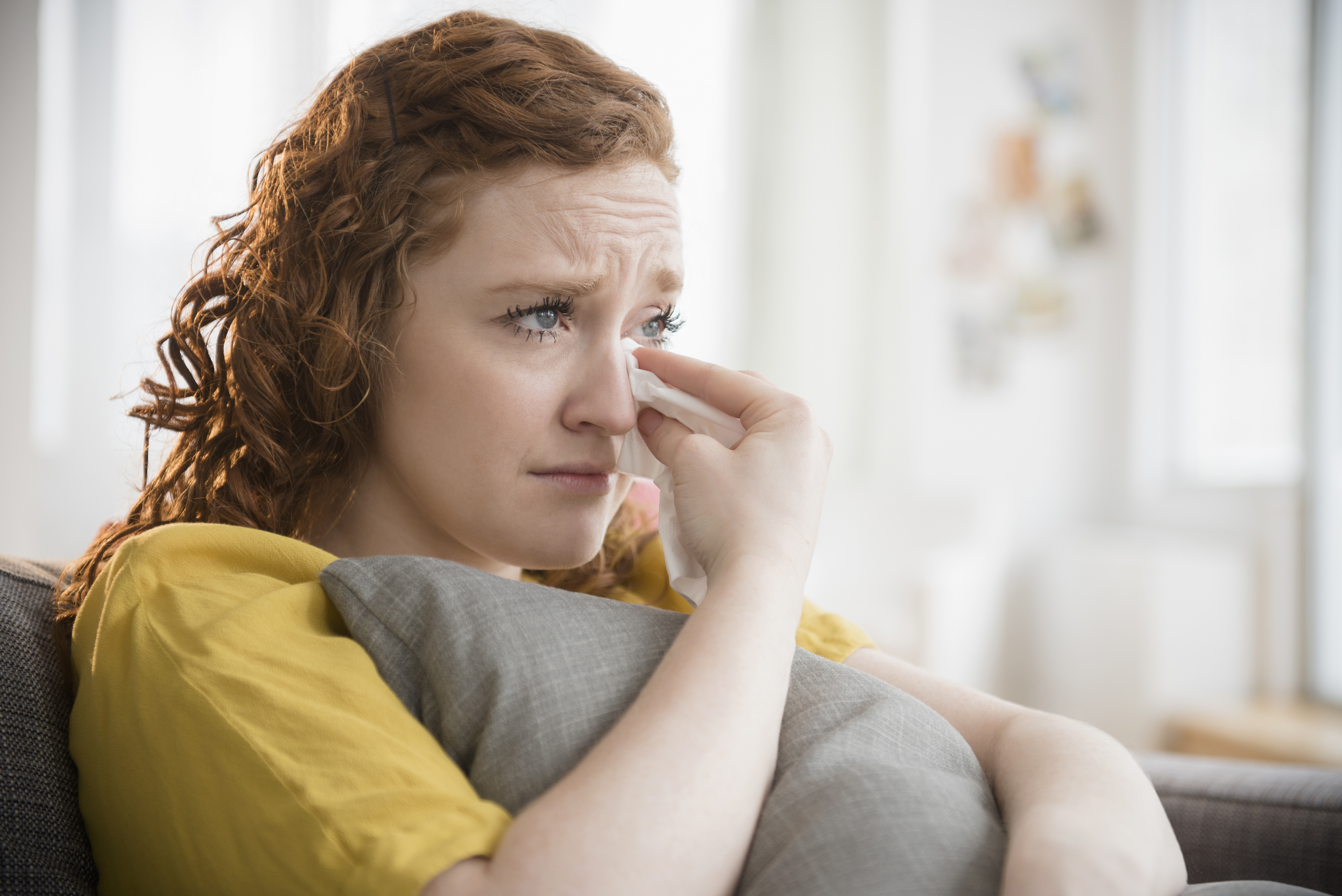 Eine weinende Frau, die sich an ein Kissen klammert | Quelle: Getty Images