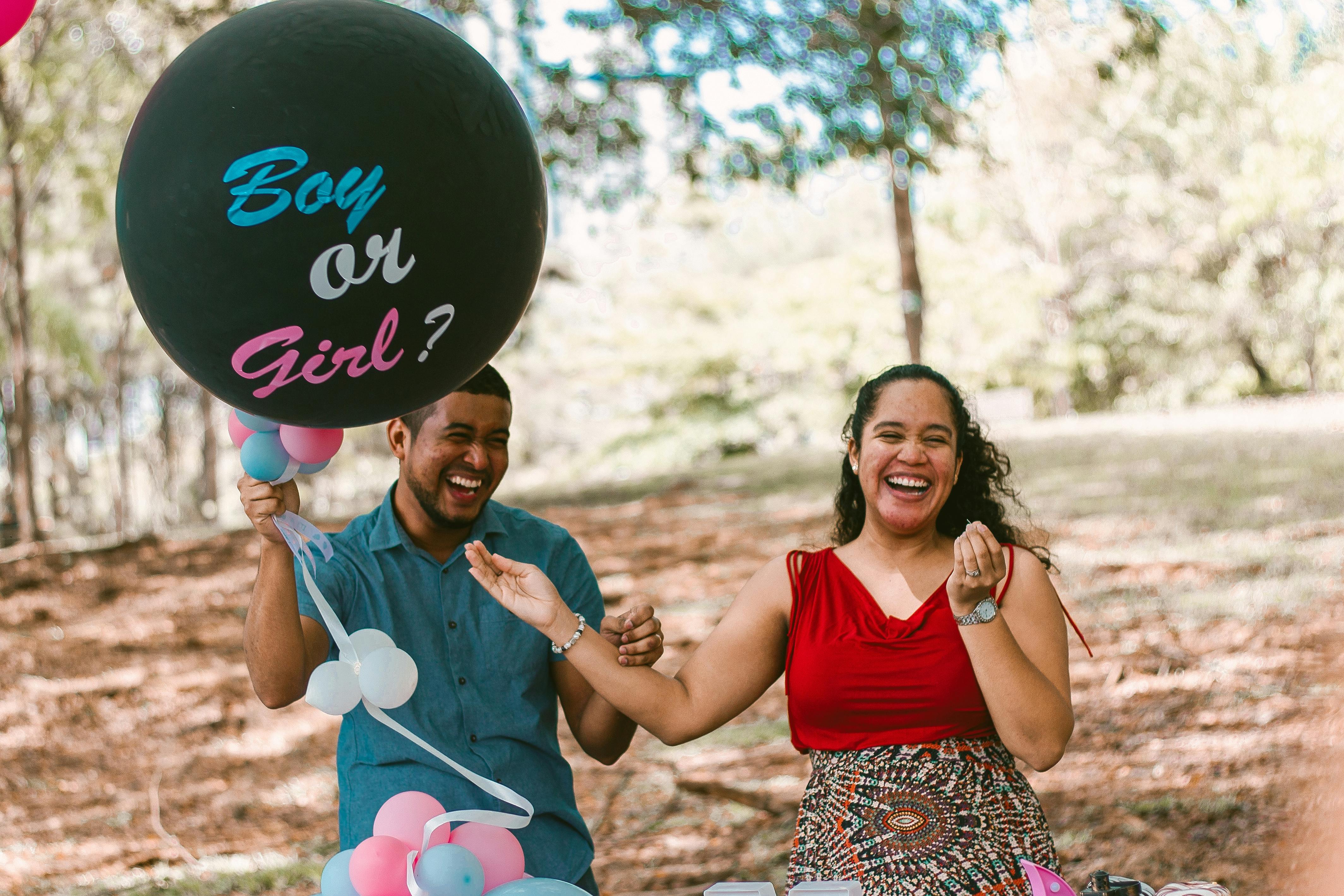 Ein Mann und eine schwangere Frau lachen bei einer Gender Reveal Party | Quelle: Pexels