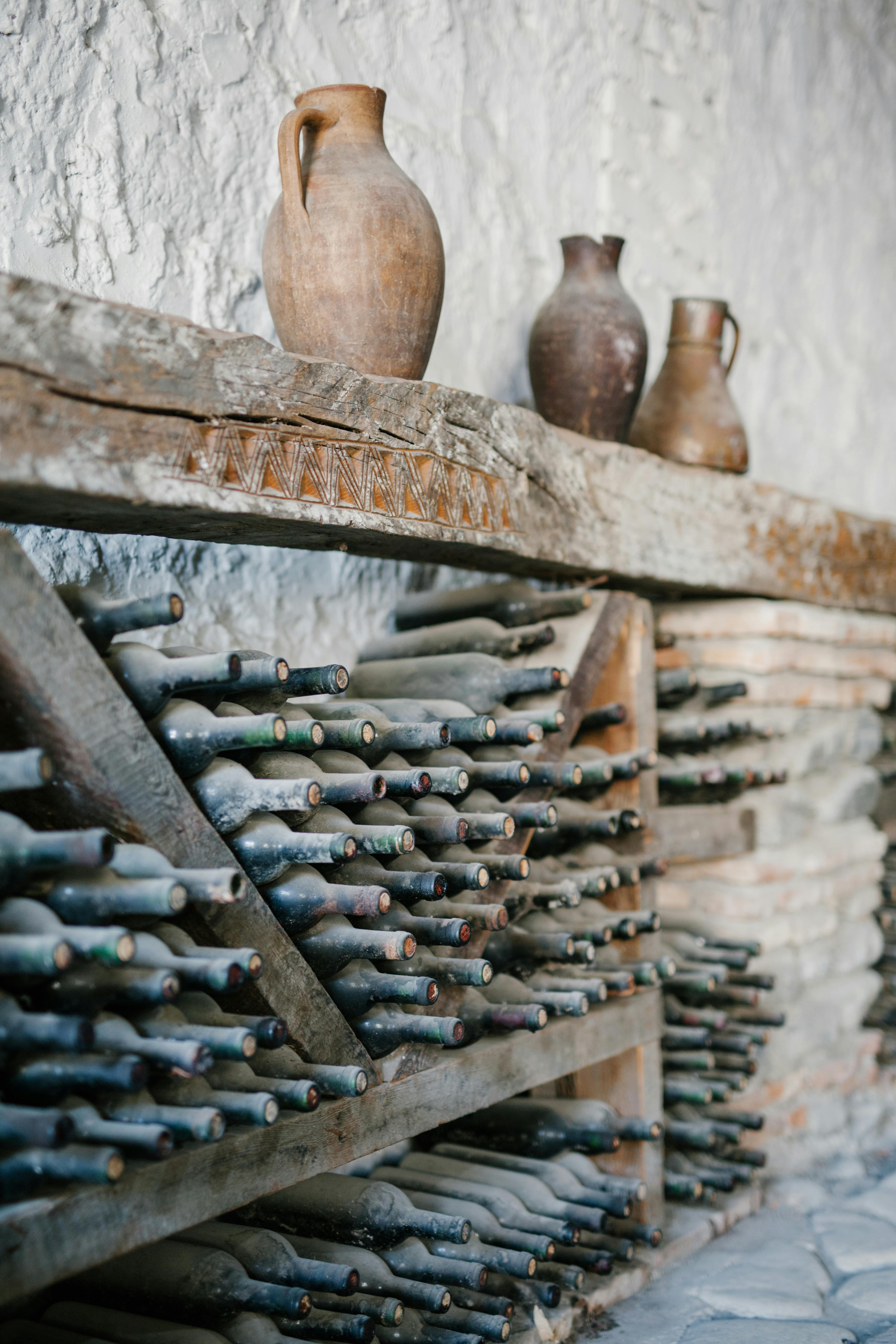 Holzregale mit verstaubten Weinflaschen aus Glas | Quelle: Pexels