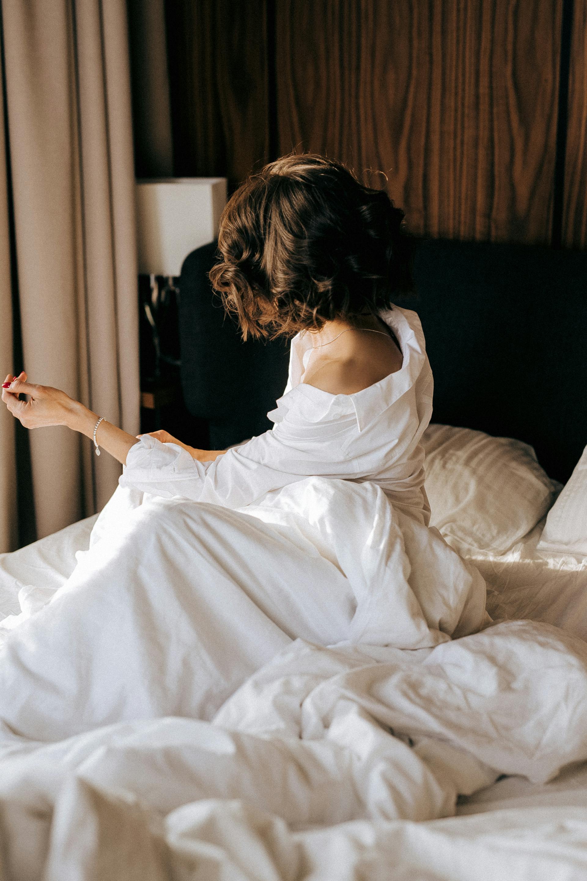 Eine Frau sitzt im Bett | Quelle: Pexels