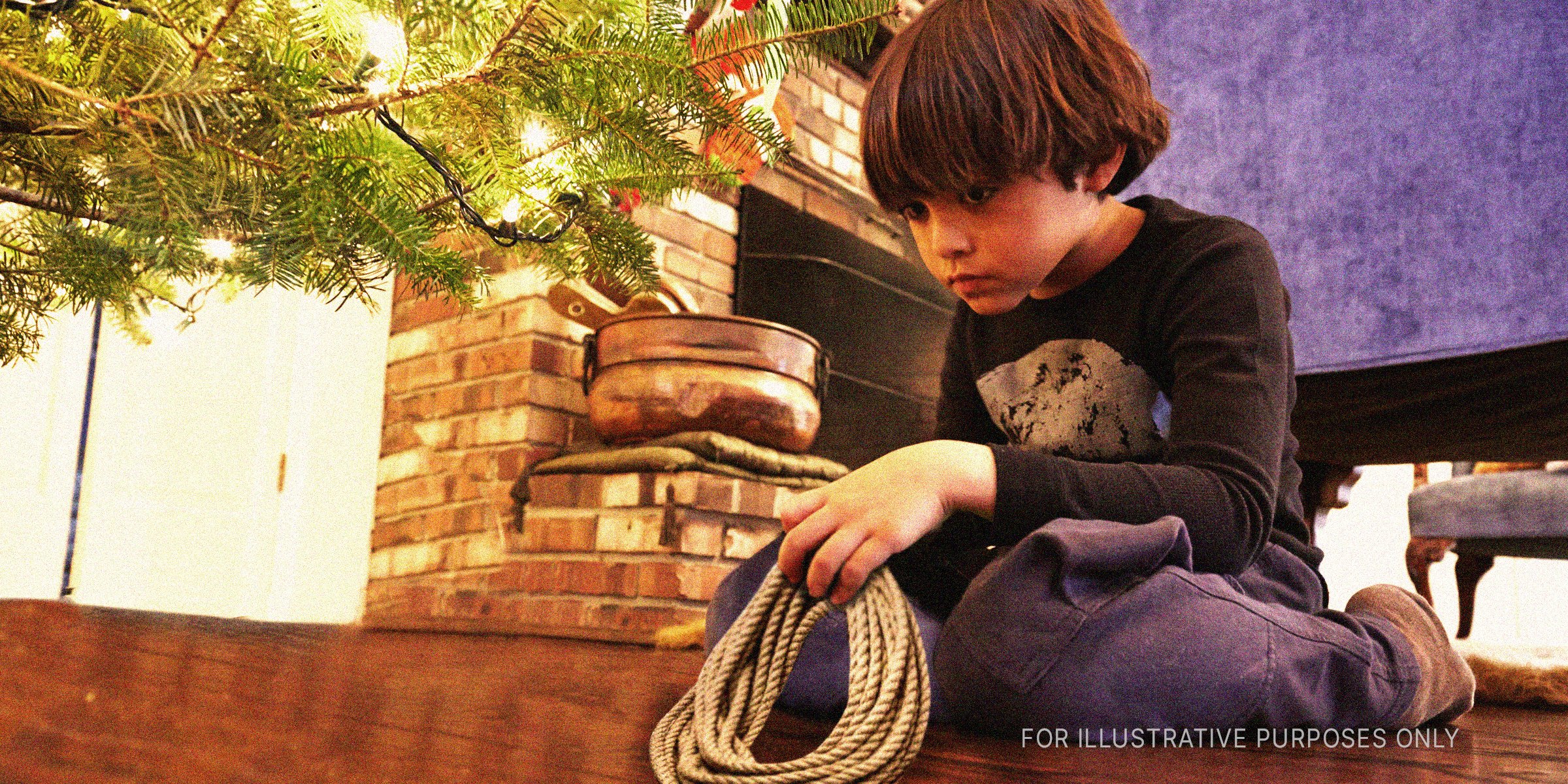 Junge mit einem Seil unter einem Weihnachtsbaum | Quelle: Getty Images