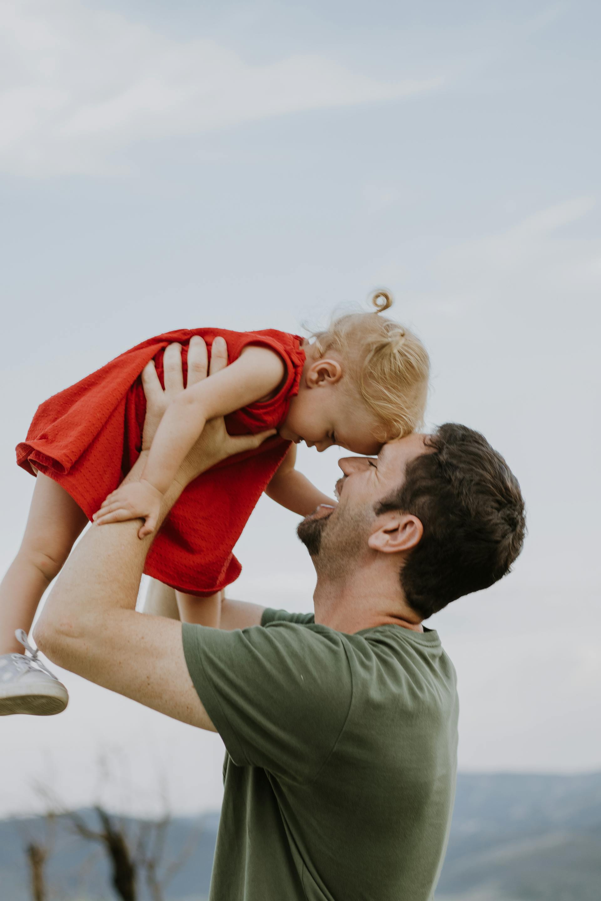 Ein glücklicher Mann hält ein kleines Mädchen | Quelle: Pexels