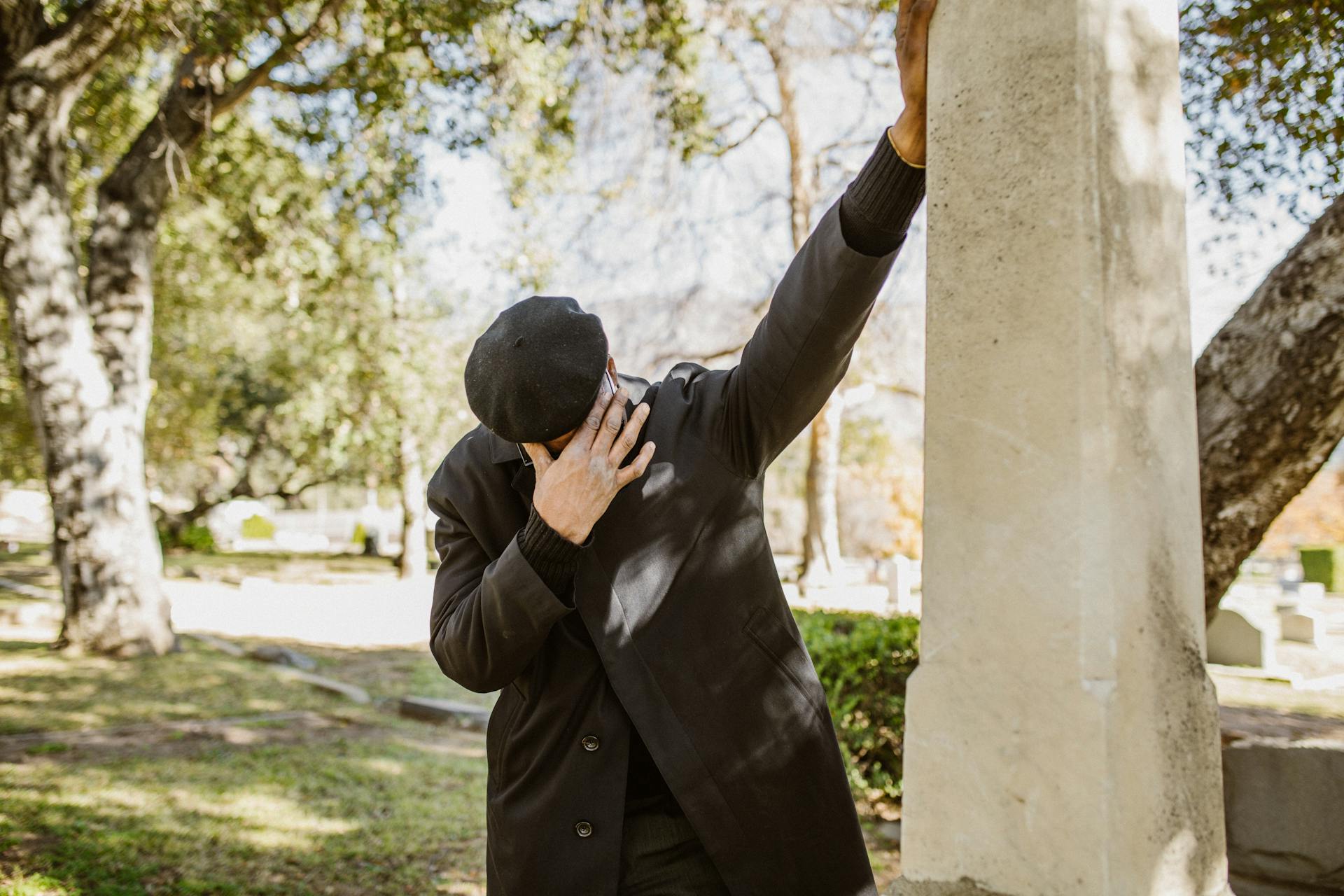 Nahaufnahme eines weinenden Mannes in einem schwarzen Anzug auf einem Friedhof | Quelle: Pexels