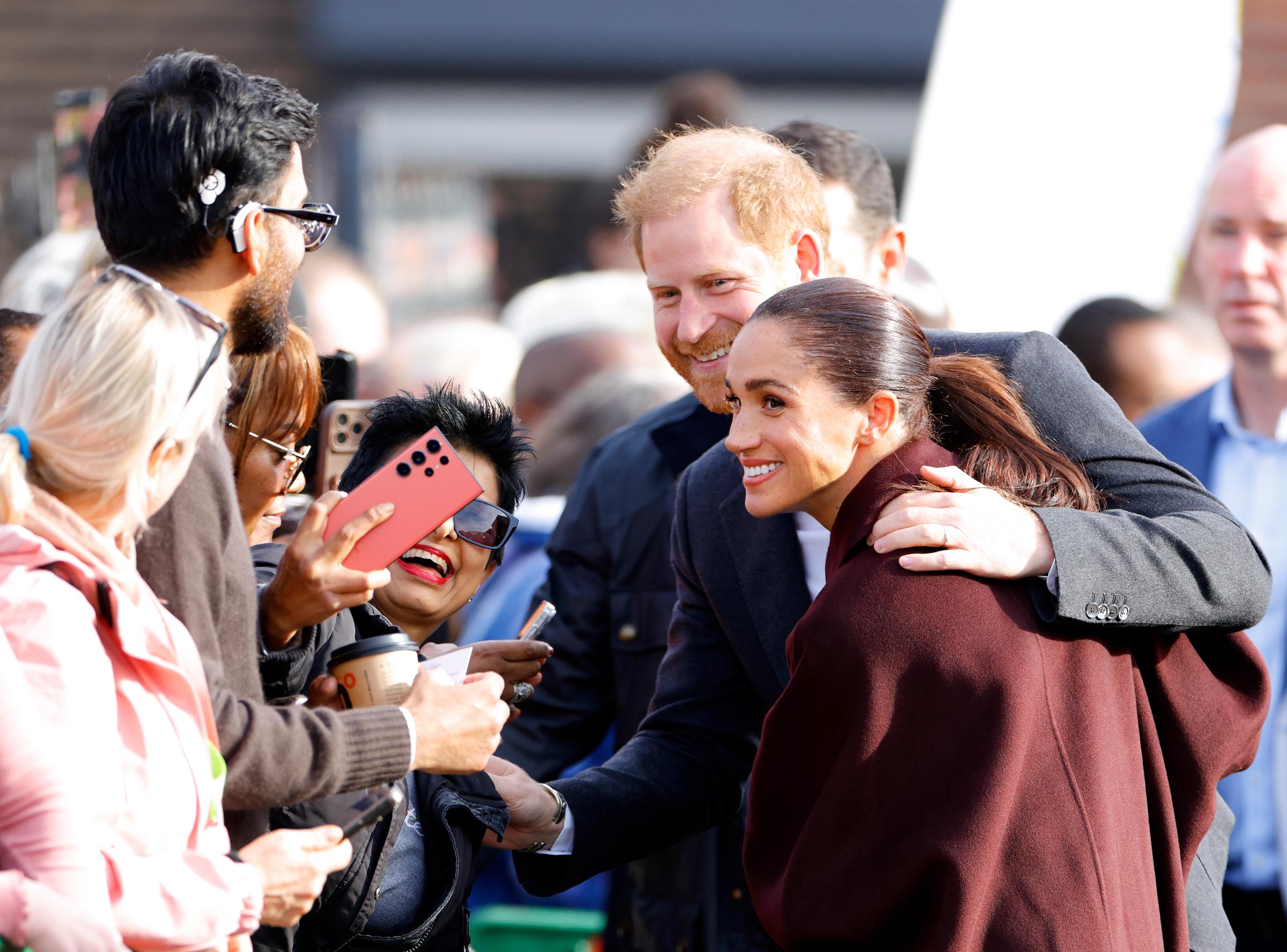 Harry hielt kurz inne, um die knallrosa Jacke einer Fanin zu bewundern, und unterhielt sich mit einem kleinen Kind, das an den Absperrseilen stand. | Quelle: Getty Images