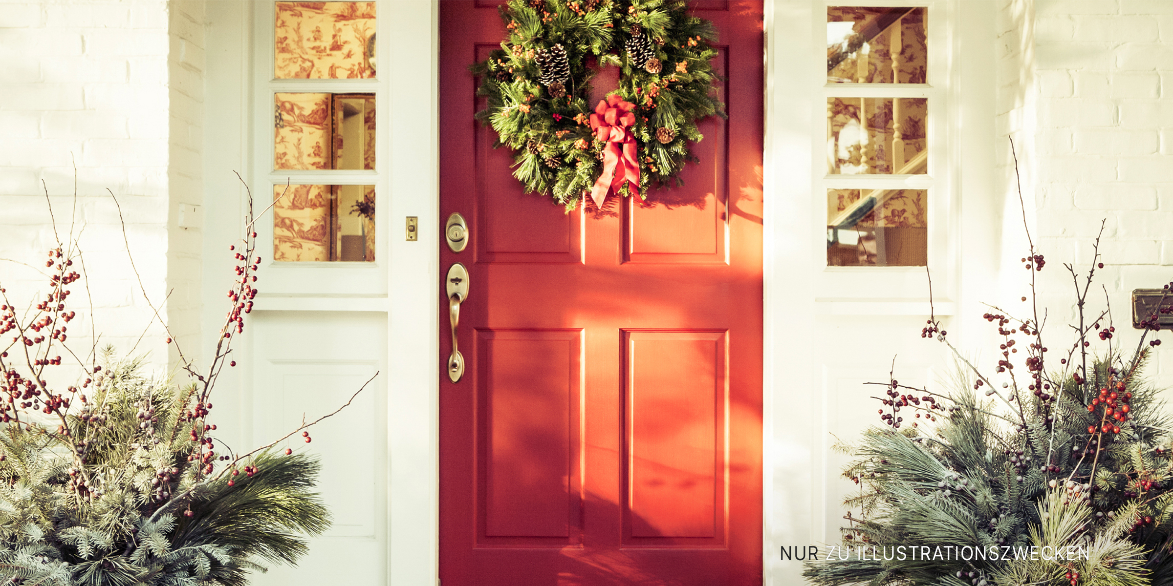Eine weihnachtlich geschmückte rote Tür | Quelle: Getty Images