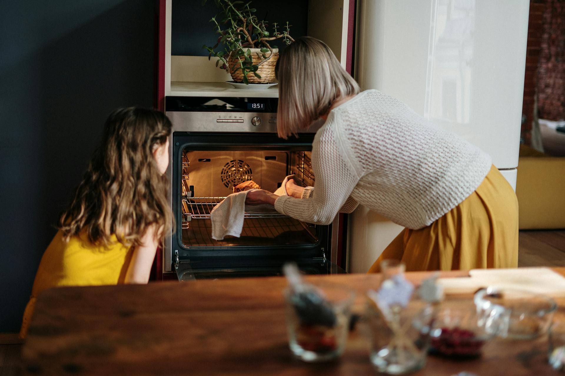 Ein Mädchen, das von einer älteren Frau das Backen lernt | Quelle: Pexels