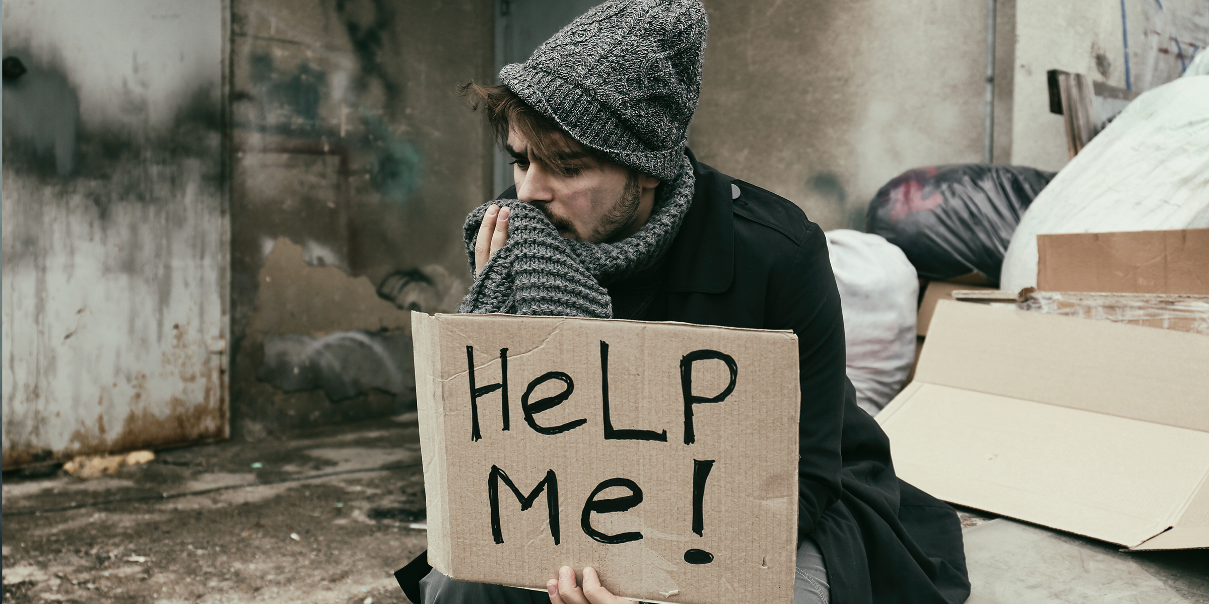 Eine obdachlose Person mit einem Schild | Quelle: Shutterstock