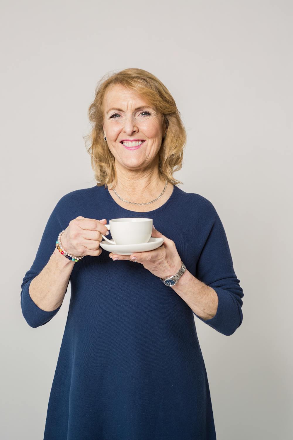 Eine lächelnde Frau mit einer Tasse Tee | Quelle: Pexels