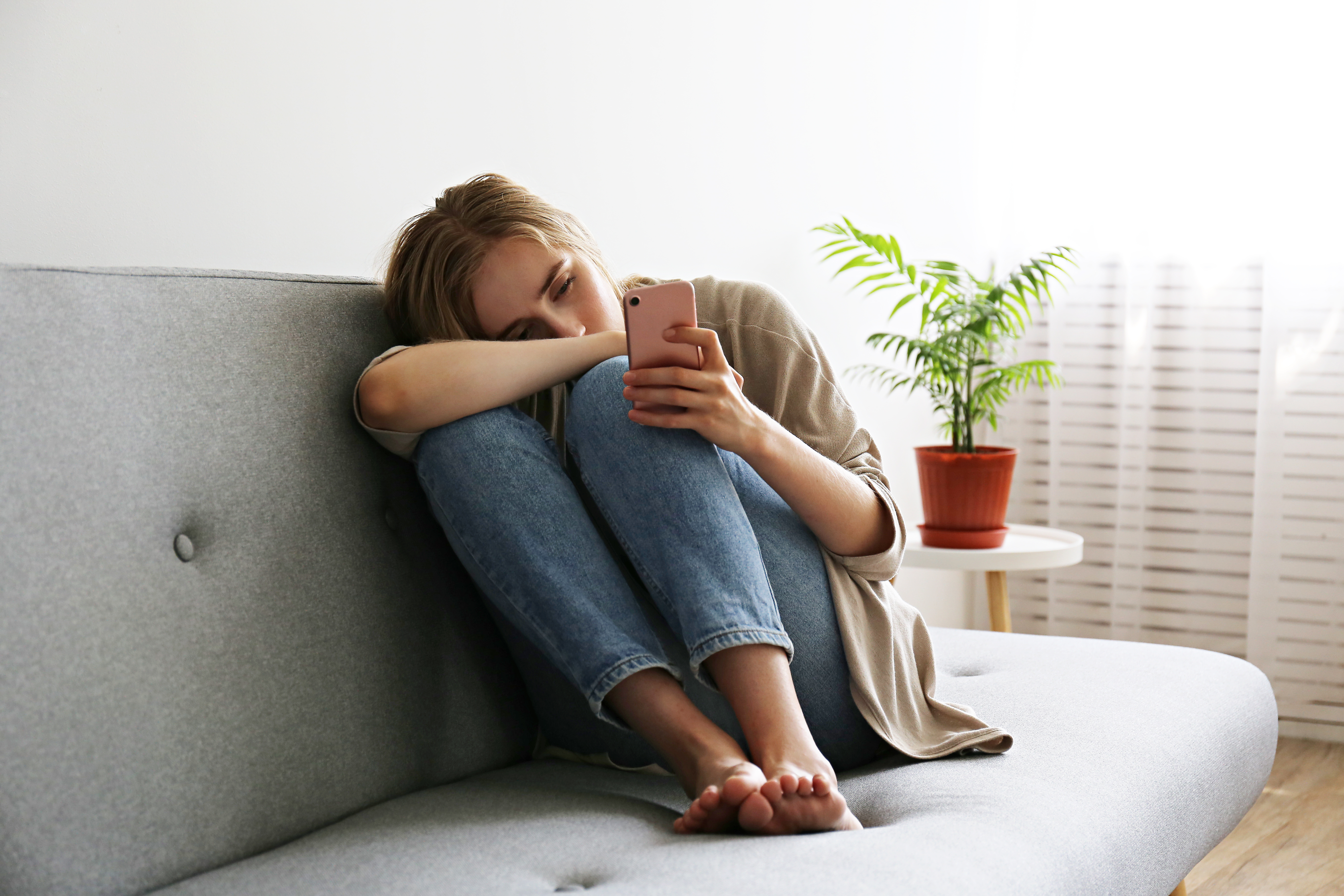 Eine junge Frau sitzt allein in ihrem Zimmer | Quelle: Shutterstock