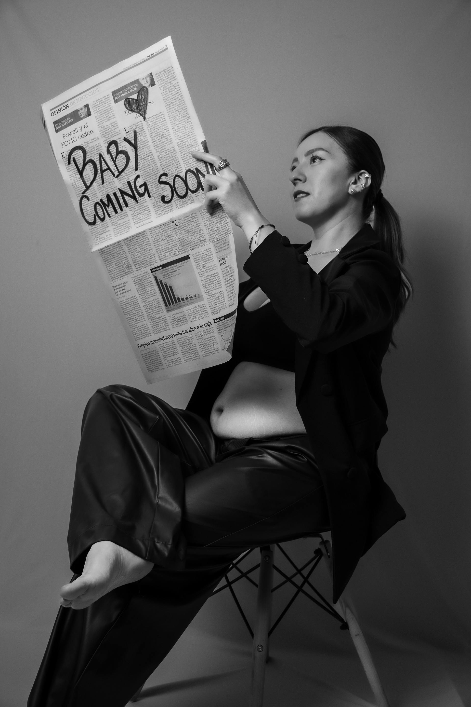 Graustufenfoto einer schwangeren Frau, die eine Zeitung hält | Quelle: Pexels